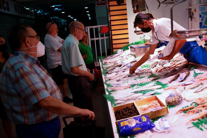 FOTO DE ARCHIVO. Vendedores de la tienda Pescados Alfonso Vicancos atienden a los clientes en un mercado local de Madrid, España. 12 de agosto de 2022. REUTERS/Susana Vera