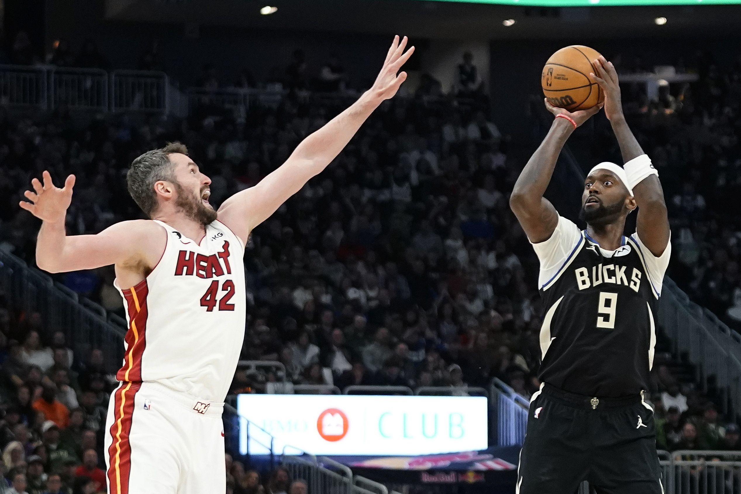 Bobby Portis, de los Bucks de Milwaukee, dispara frente a Kevin Love, del Heat de Miami, en el segundo partido de la serie de primera ronda de los playoffs, el miércoles 19 de abril de 2023 (AP Foto/Aaron Gash)