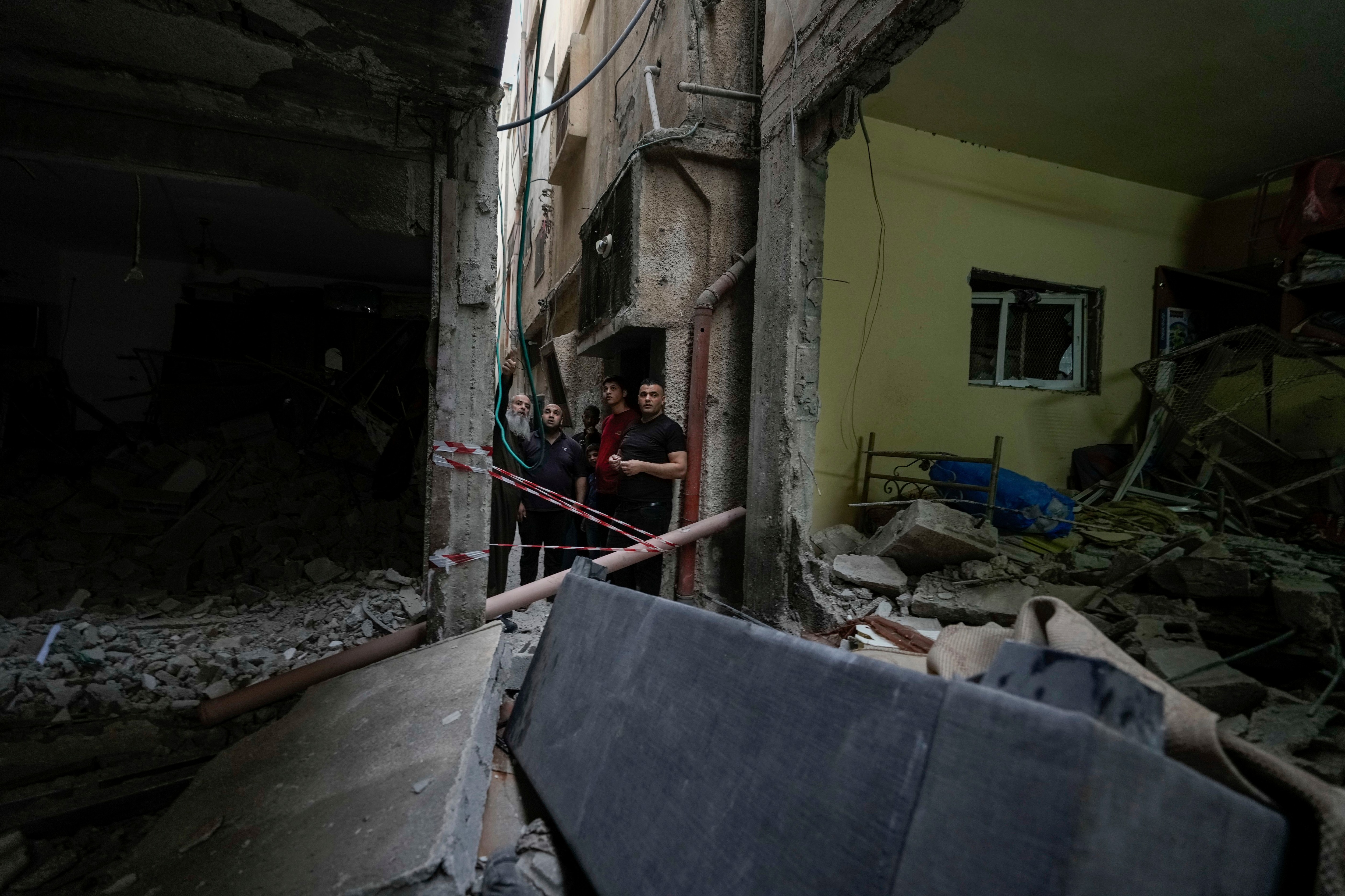 Palestinos revisan un edificio dañado tras una incursión militar israelí en el campo de refugiados de Balata, cerca de la localidad cisjordana de Nablus el lunes 22 de mayo de 2023. Al menos tres personas murieron por fuego israelí durante la redada en el campo de refugiados, según autoridades palestinas de salud. (AP Foto/Majdi Mohammed)