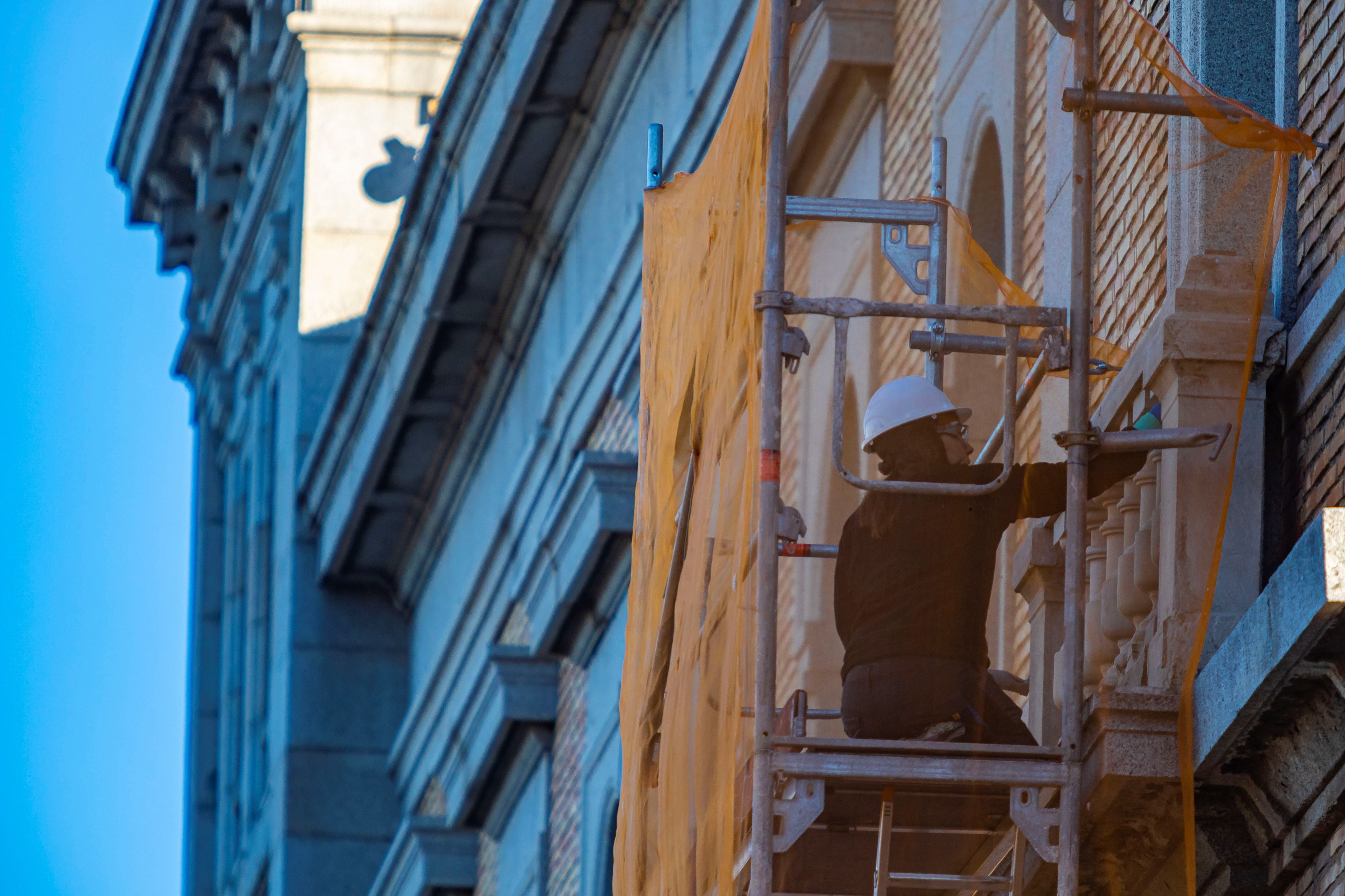 Una empleada de la construcción trabaja en la fachada de un edificio de Toledo. (EFE/Ángeles Visdómine).
