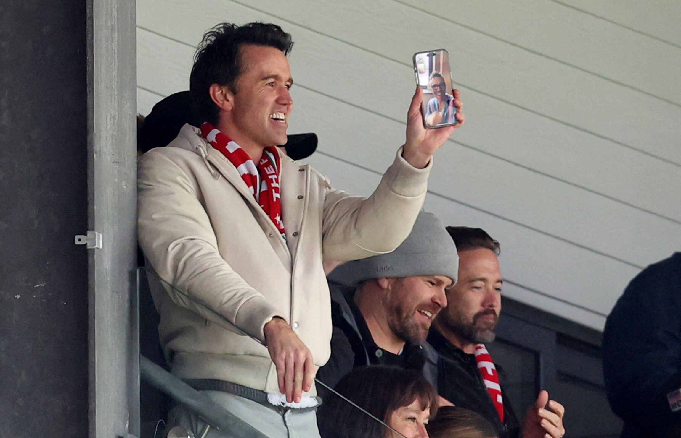 Soccer Football - League Two - Wrexham v Stockport County - Racecourse Ground, Wrexham, Wales, Britain - April 27, 2024 Wrexham co-owner Rob McElhenney makes a video call to Wrexham co-owner Ryan Reynolds after they score their second goal Action Images via Reuters/Ed Sykes  EDITORIAL USE ONLY. No use with unauthorized audio, video, data, fixture lists, club/league logos or "live" services. Online in-match use limited to 75 images, no video emulation. No use in betting, games or single club/league/player publications.  Please contact your account representative for further details.