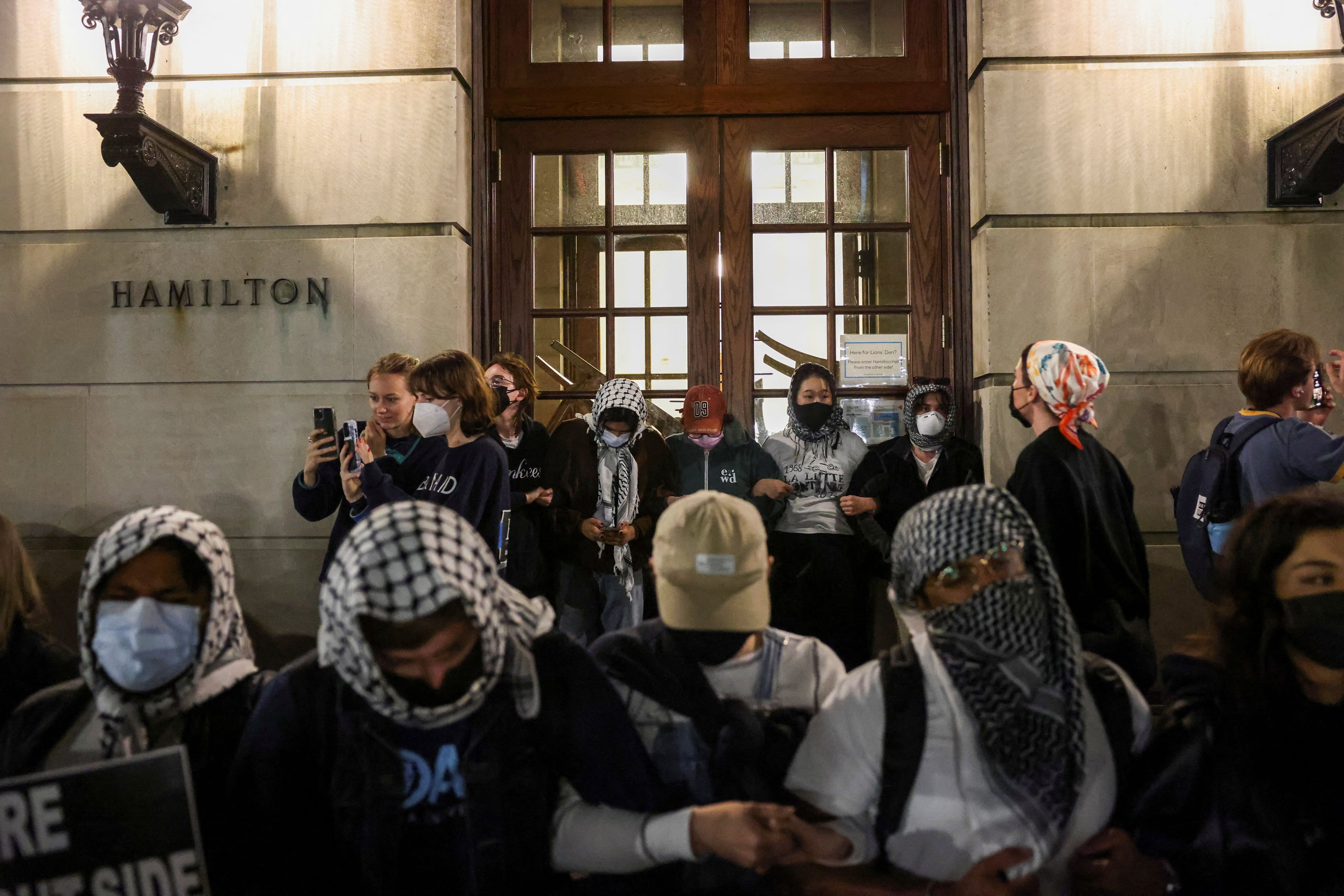 Estudiantes en el campus de Manhattan de Columbia con los brazos entrelazados ante el Hamilton Hall (REUTERS/Caitlin Ochs)