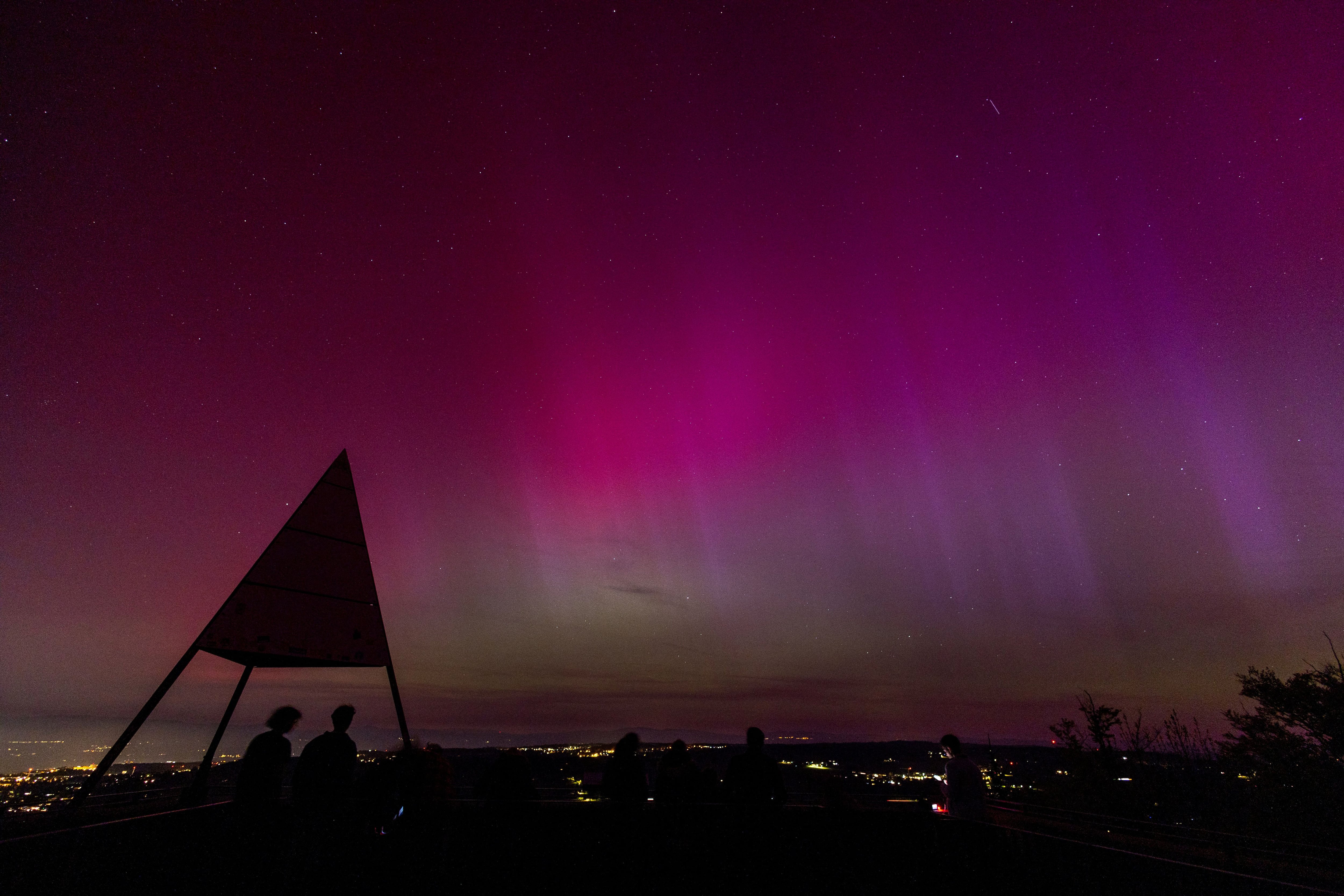 Una aurora boreal se ve por encima de Lausana y el Jura desde el Tour de Gourze en Riex, Suiza, este 11 de mayo de 2024 (Foto: REUTERS)