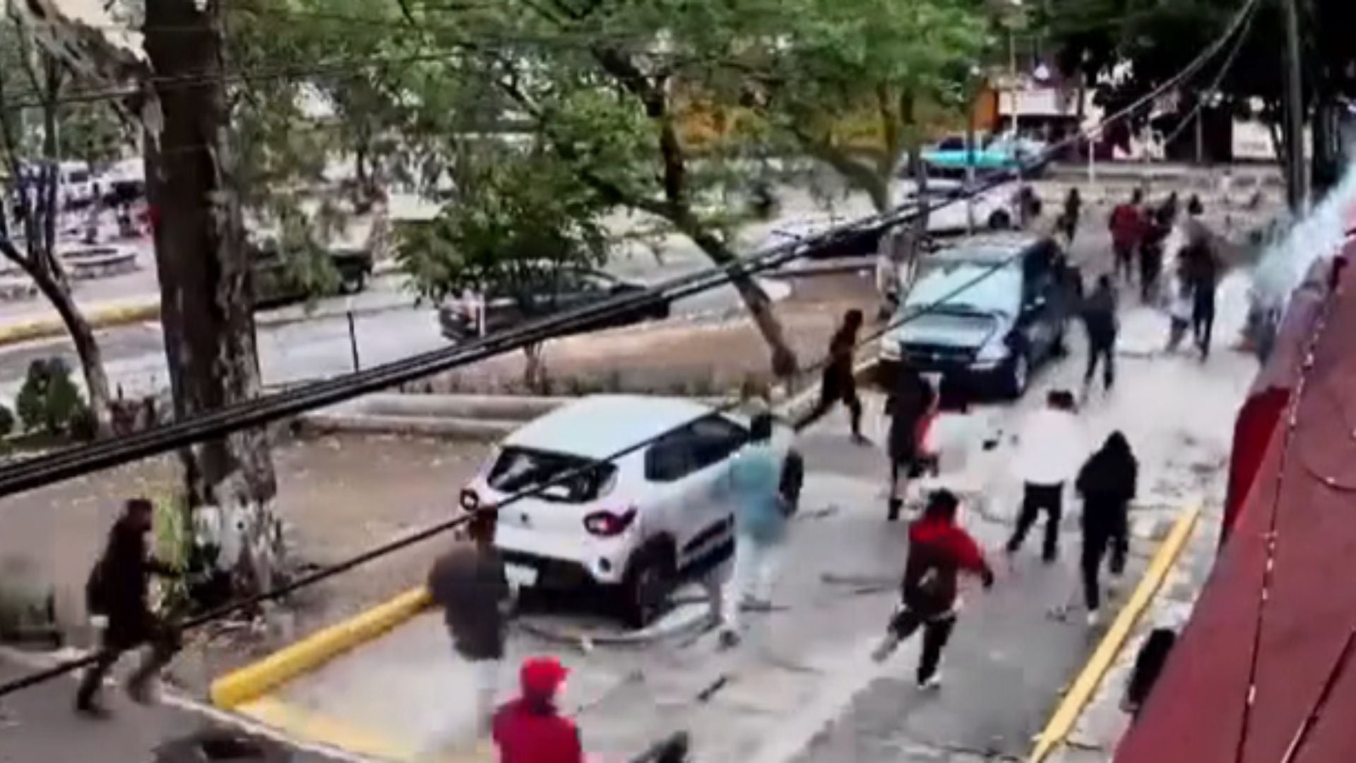 Los aparentes miembros de un grupo porril arrojaron petardos contra los estudiantes. (Captura de pantalla)