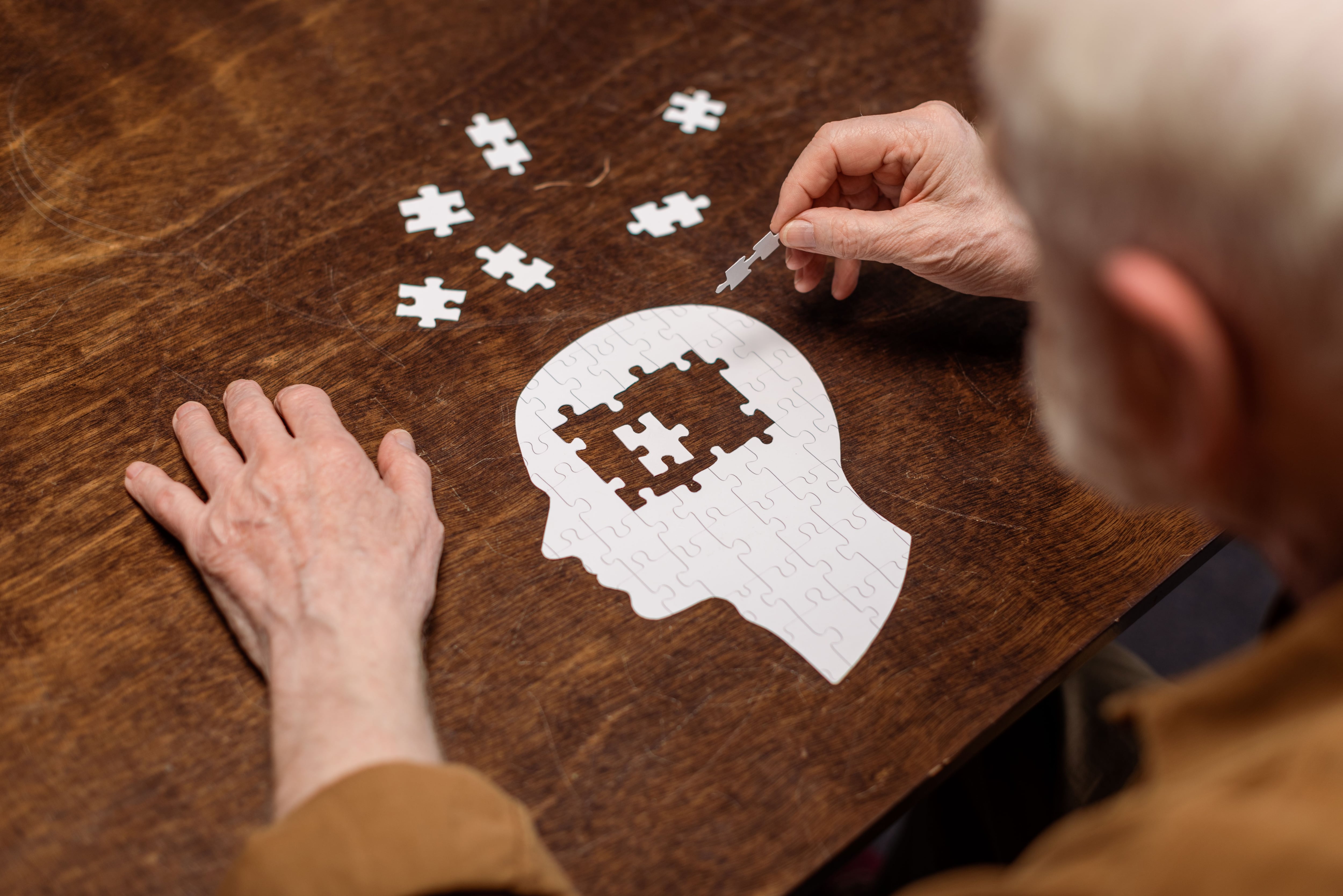 Señor mayor ejercitando su memoria con un puzzle (Shutterstock)