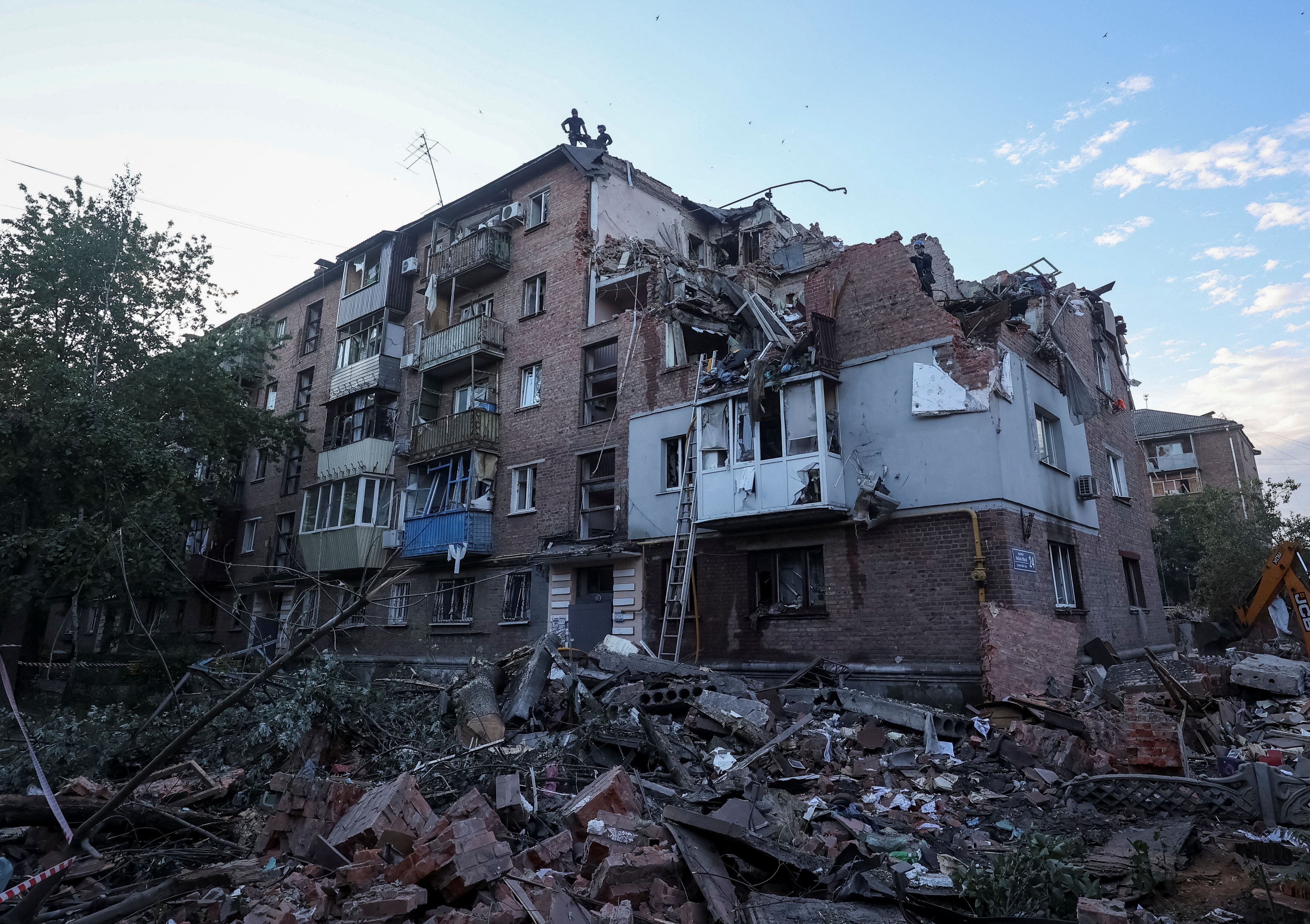 Rescatistas trabajan en el sitio de un edificio residencial golpeado por un ataque con misiles rusos en Kharkiv (REUTERS/Vyacheslav Madiyevskyy)