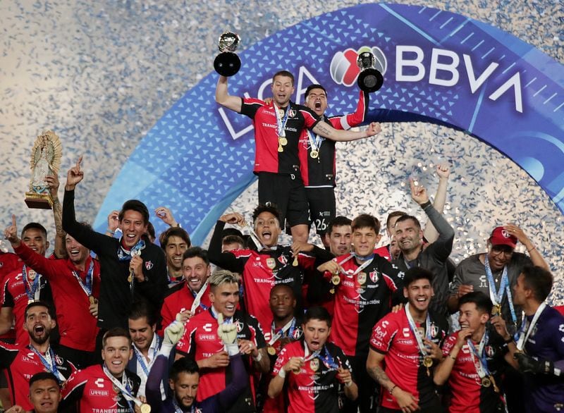 El capitán de Atlas, Aldo Rocha, y el defensor argentino Hugo Nervo alzan el trofeo de campeón junto a sus compañeros. Estadio Hidalgo, Pachuca, México. 29 de mayo de 2022.
REUTERS/Henry Romero