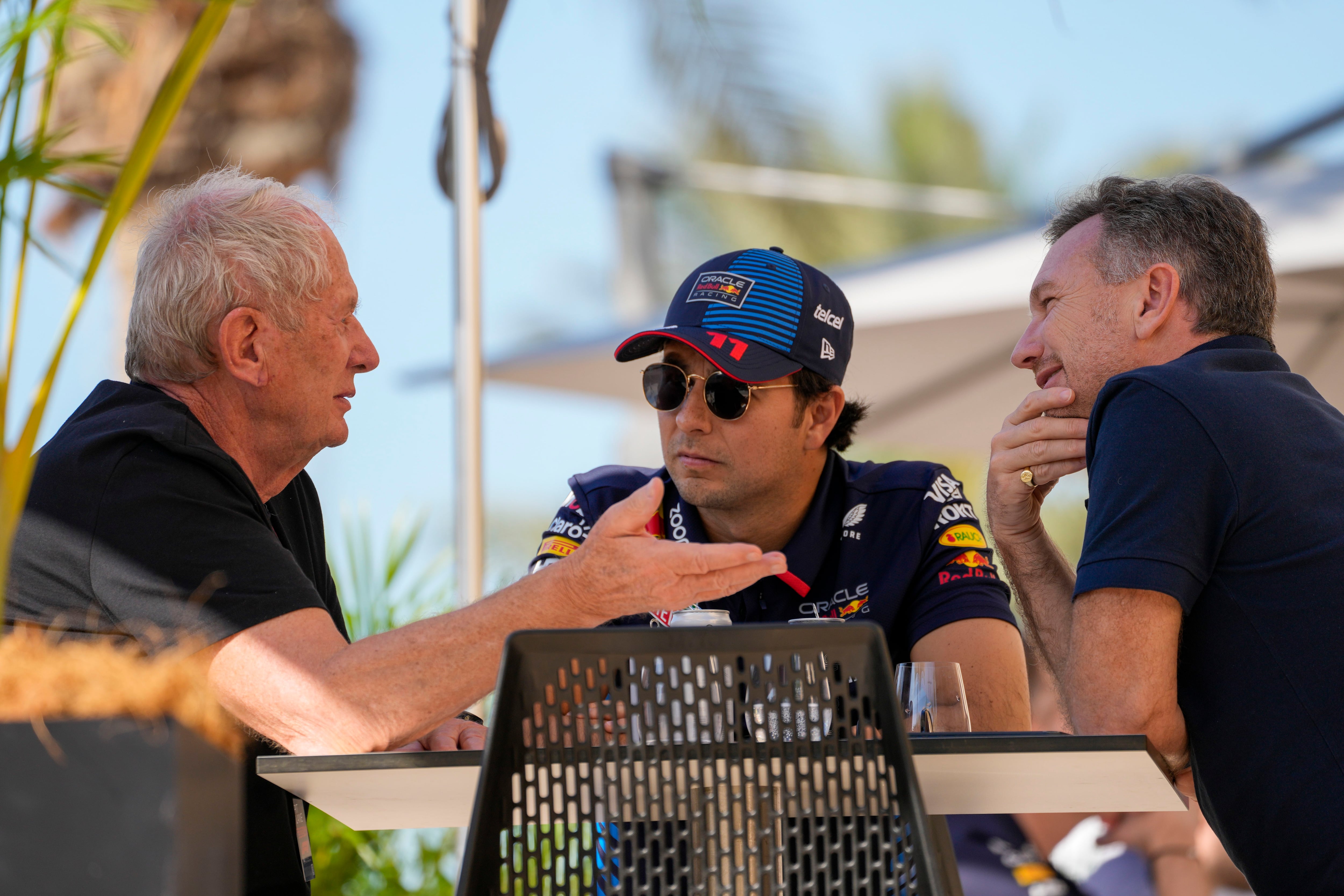 El jefe de Red Bull Christian Horner habla con el piloto Sergio Pérez y con el director de equipos de la Red Bull en la F1 Helmut Marko en Sahir, Bahrein el miércoles 21 de febrero del 2024. (AP Foto/Darko Bandic)