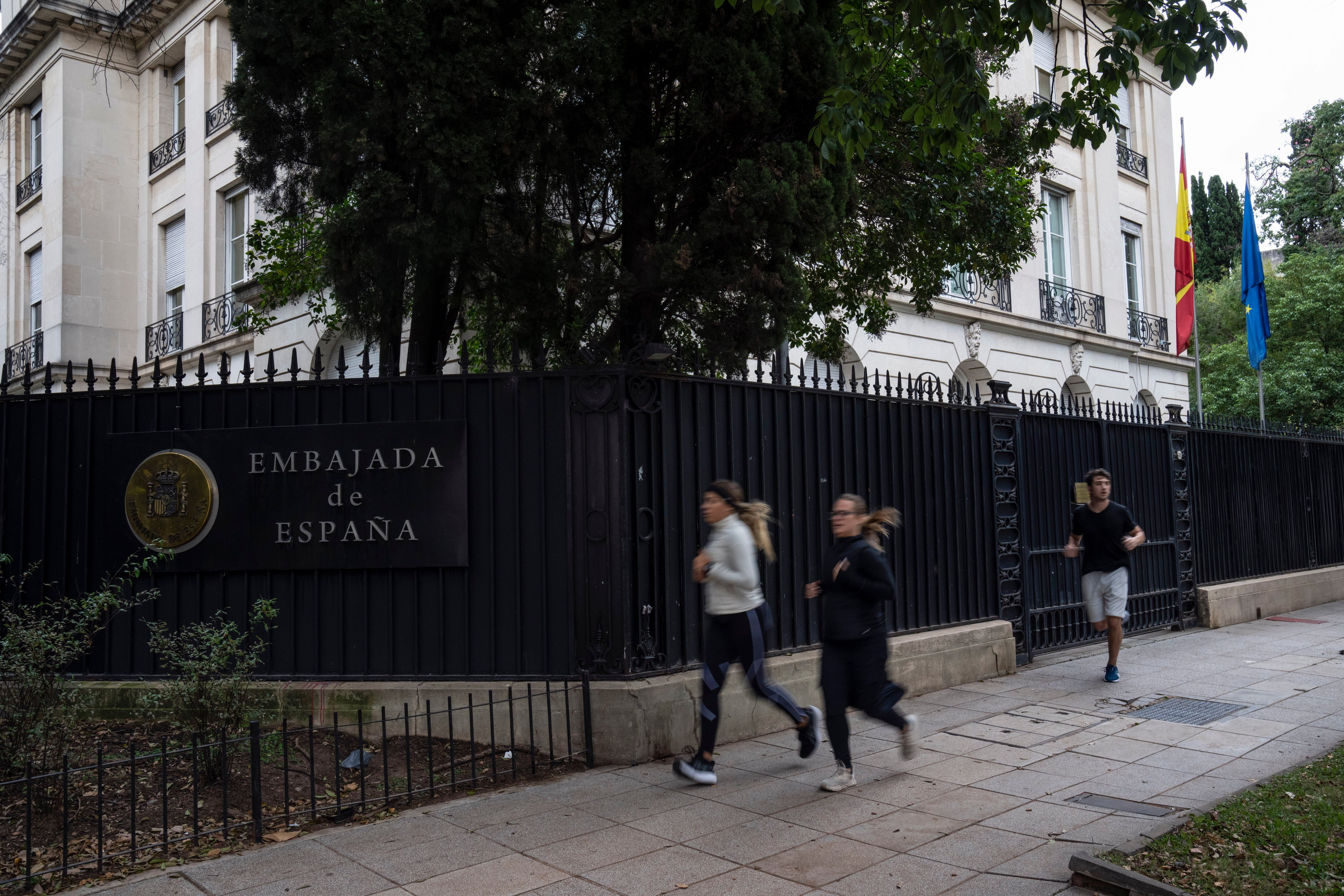 Varias personas corren frente a la embajada de España en el barrio de Palermo de Buenos Aires, Argentina, el martes 21 de mayo de 2024. (AP Foto/Rodrigo Abd)