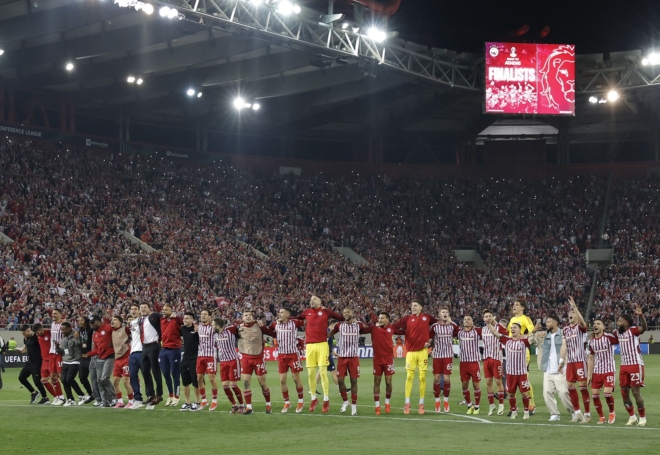 Los jugadores del Olympiakos celebrando ante su hinchada la clasificación a la final de Conference League, tras eliminar al Aston Villa por marcador global de 6-2 - crédito Alkis Konstantinidis/REUTERS