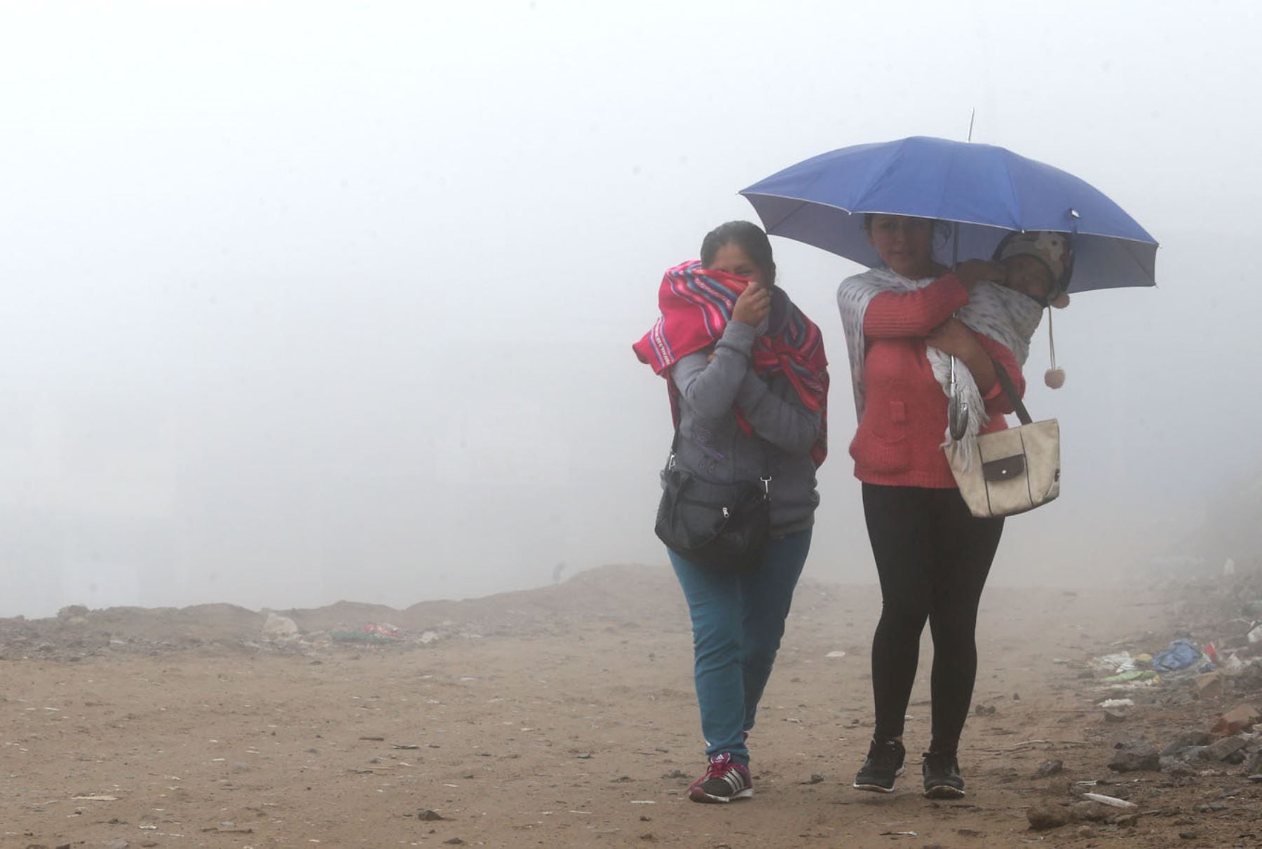 Dos vecinas de una zona periférica de Lima soportan la niebla y temperaturas bajas de un temporada de otoño bastante fría.