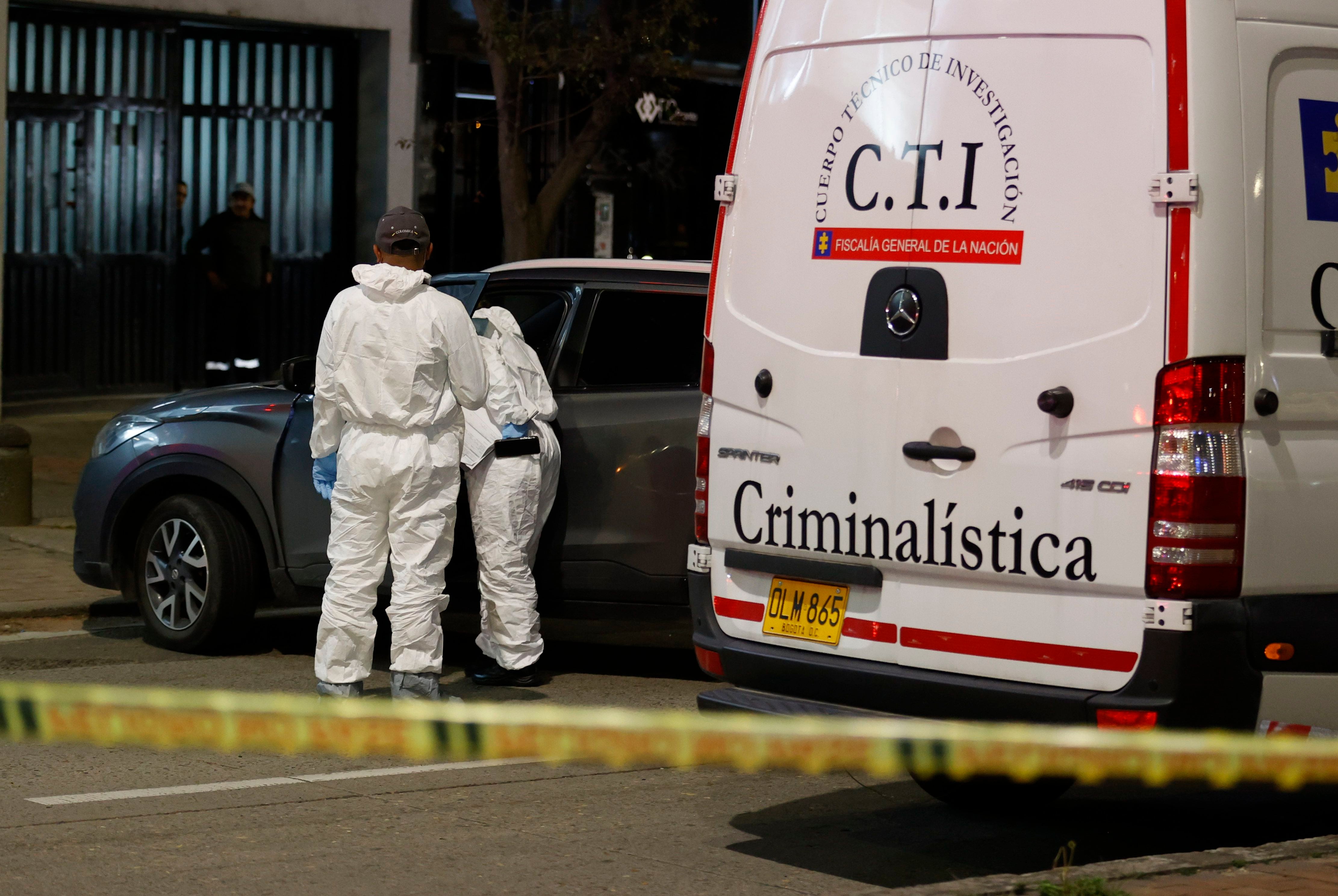 Agentes del Cuerpo Técnico de Investigación (C.T.I) de la Fiscalía investigan la zona donde el director de la cárcel La Modelo de Bogotá, el coronel retirado de la Policía Élmer Fernández, fue asesinado este jueves por sicarios que lo atacaron a tiros cuando se movilizaba en un vehículo oficial - crédito Mauricio Dueñas Castañeda/EFE
