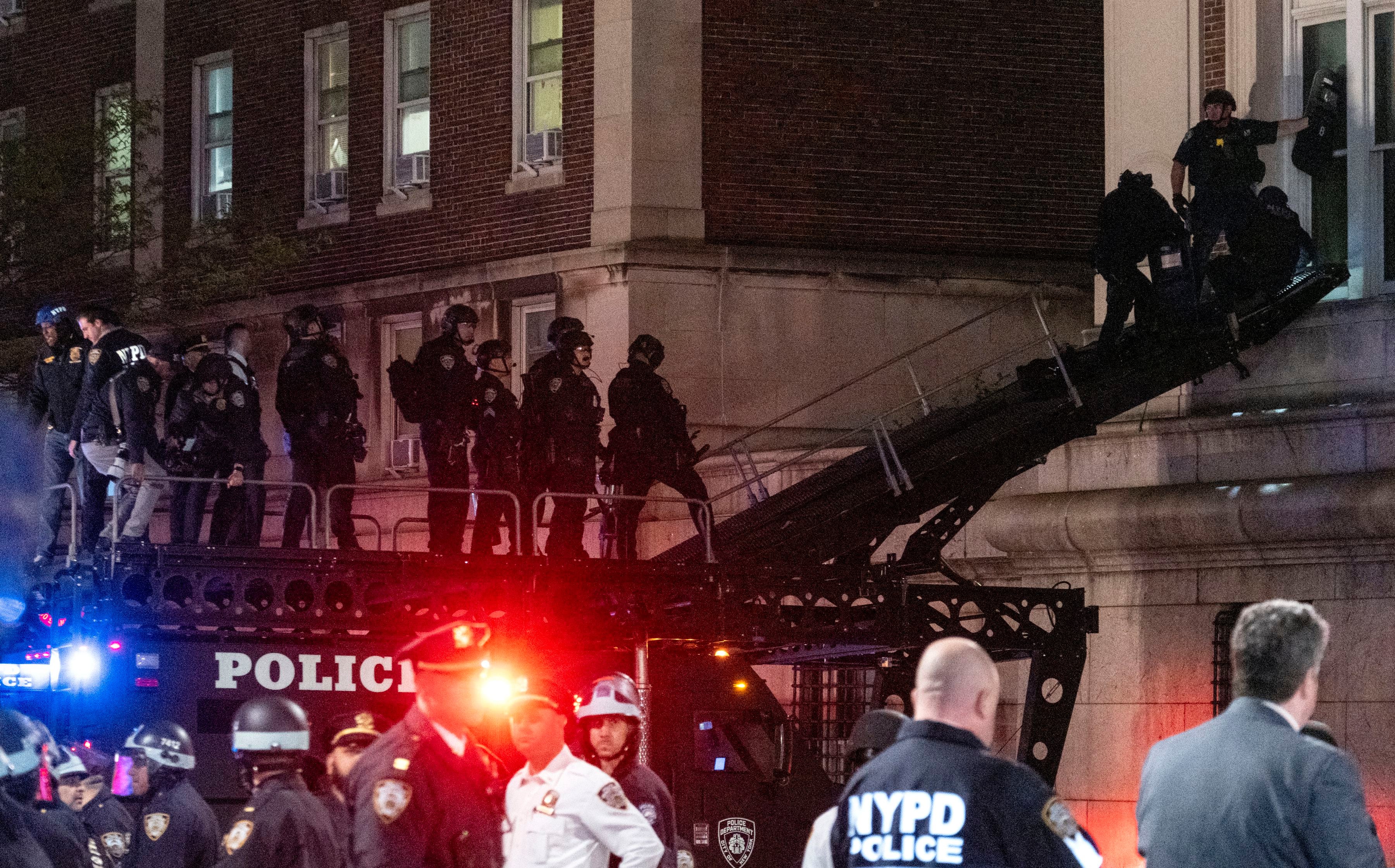 Policías de Nueva York utilizan un vehículo táctico para llegar a un piso superior del edificio Hamilton en el campus de la Universidad de Columbia (AP Foto/Craig Ruttle)