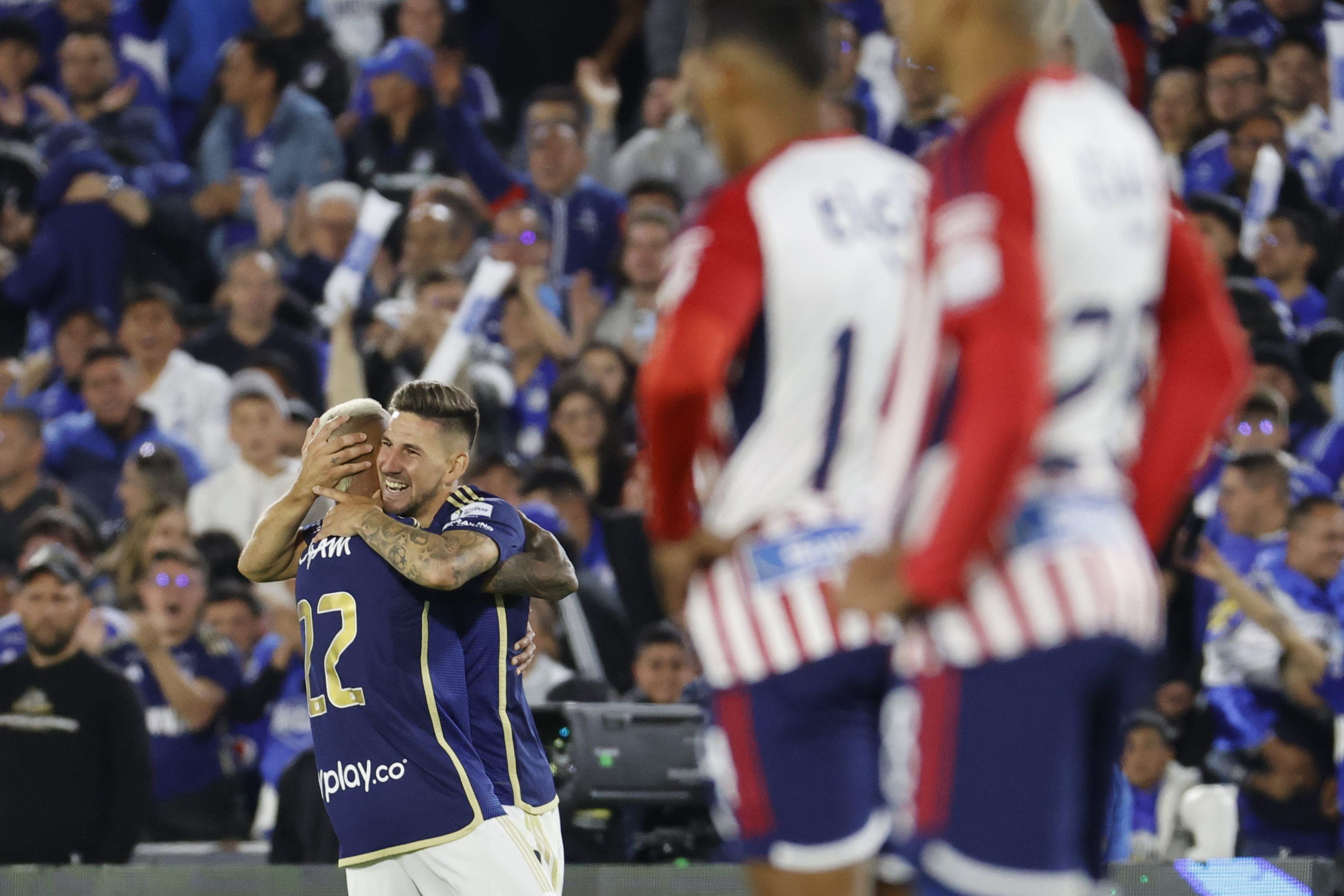 Fotografía de archivo, tomada el pasado 24 de enero, en la que se registró una celebración de Santiago Giordana (c) y Lenardo Castro (i), delanteros de Millonarios, tras anotarle un gol al Junior de Barranquilla, durante la final de la Superliga colombiana de fútbol, en el estadio El Campín de Bogotá (Colombia). Este fue el más reciente enfrentamiento entre ambos clubes. EFE/Mauricio Dueñas
