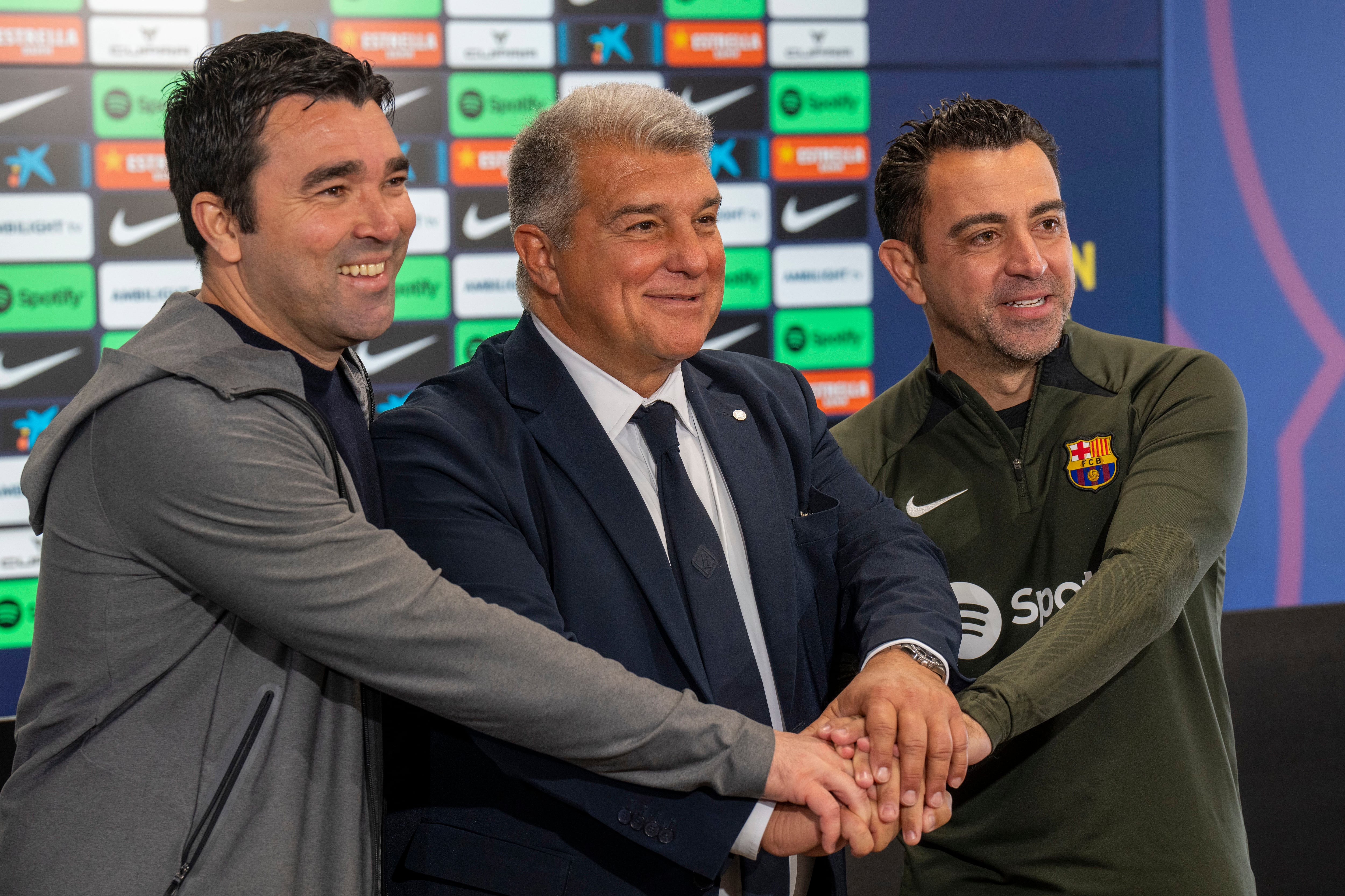 El técnico del Barcelona Xavi Hernández (derecha), el presidente Joan Laporta (centro) y el director deportivo Deco durante la rueda de prensa en la que anunciaron la continuidad del técnico (AP Foto/Emilio Morenatti)