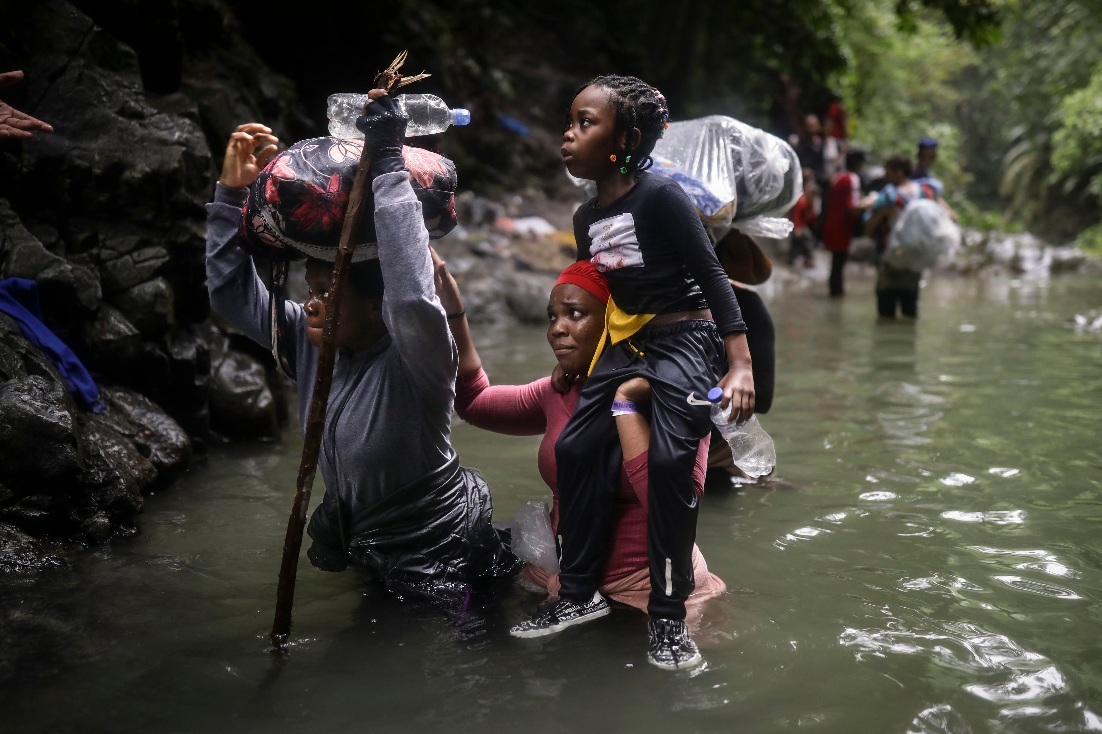 Migrantes haitianos vadean el agua mientras cruzan la región del Darién de Colombia a Panamá con la esperanza de llegar a la frontera sur de Estados Unidos, el martes 9 de mayo de 2023. La imagen fue parte de una serie tomada por los fotógrafos de The Associated Press Iván Valencia, Eduardo Verdugo, Félix Márquez, Marco Ugarte, Fernando Llano, Eric Gay, Gregory Bull y Christian Chávez que ganó el Premio Pulitzer 2024 en Fotografía de Reportaje. (AP Foto/Iván Valencia)