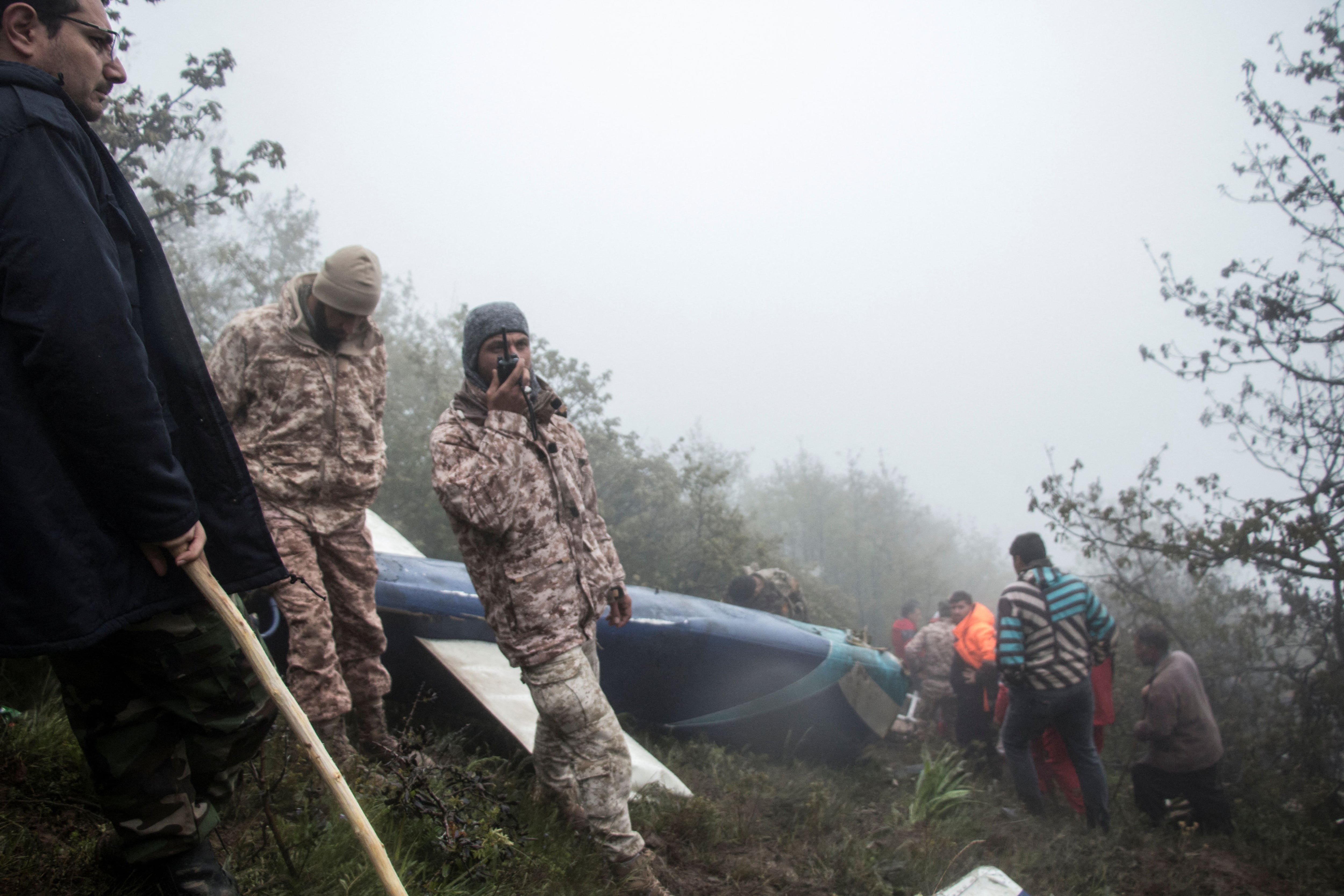 Los equipos de rescate cerca de los restos del helicóptero (WANA via REUTERS)