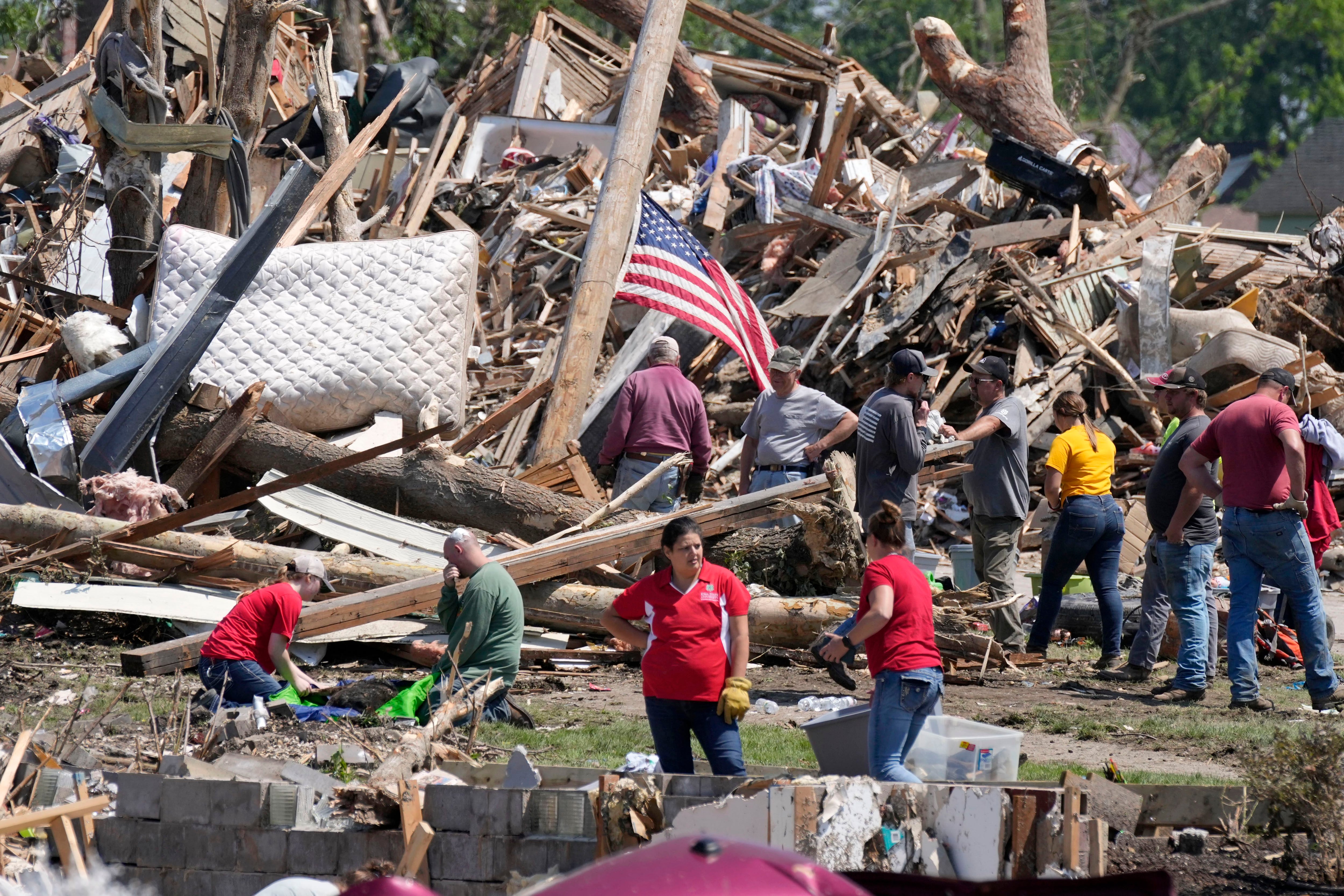 Residentes retiran los escombros de una casa dañada por un tornado, el miércoles 22 de mayo de 2024 en Greenfield, Iowa. (AP Foto/Charlie Neibergall)