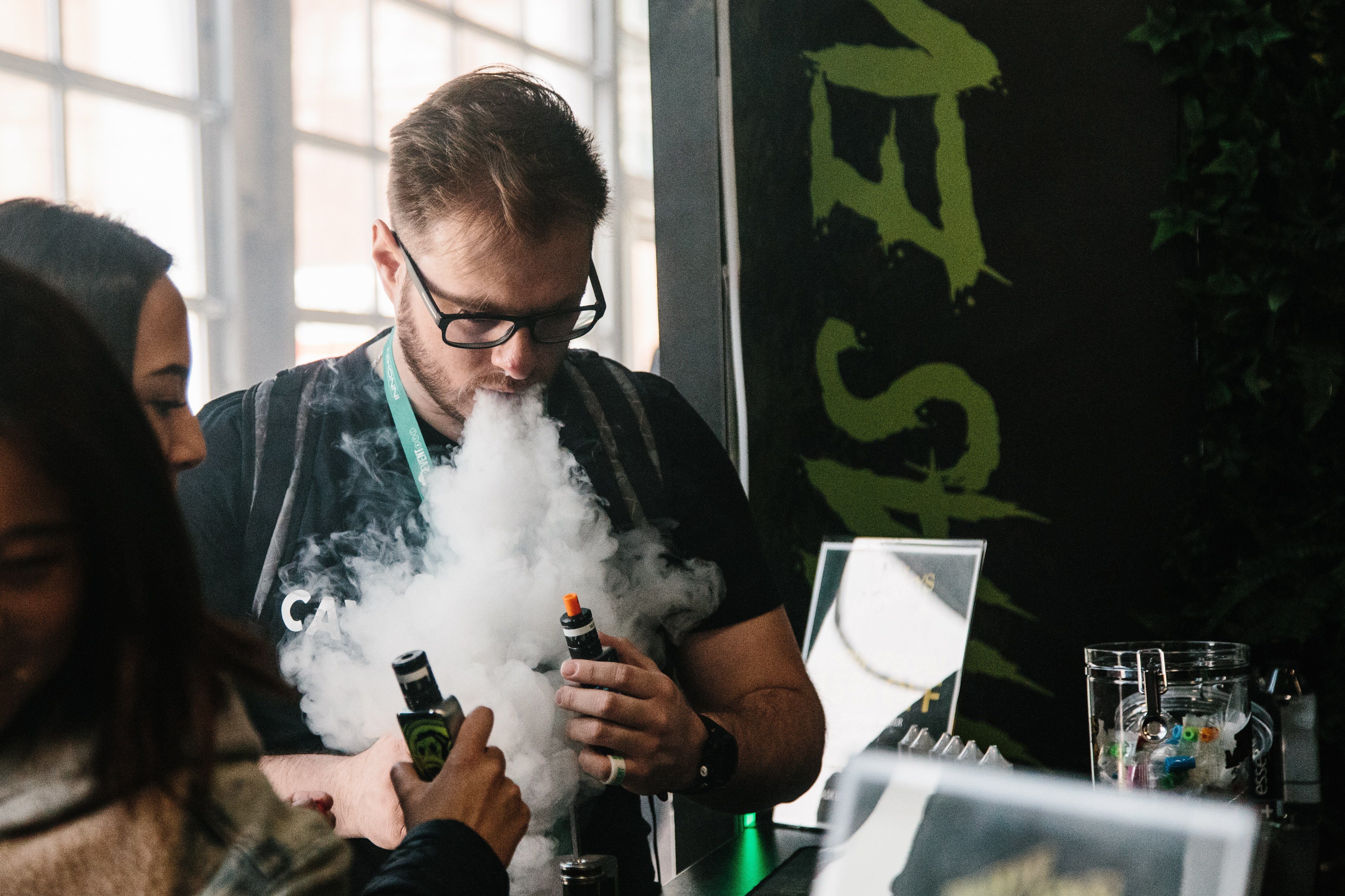 Un hombre expulsa vapor por la boca durante la tercera edición de "Vapevent Trade Show", una feria comercial que recoge las últimas tendencias de vapeo, en Nueva York (Estados Unidos), en una imagen de archivo. EFE/ Alba Vigaray
