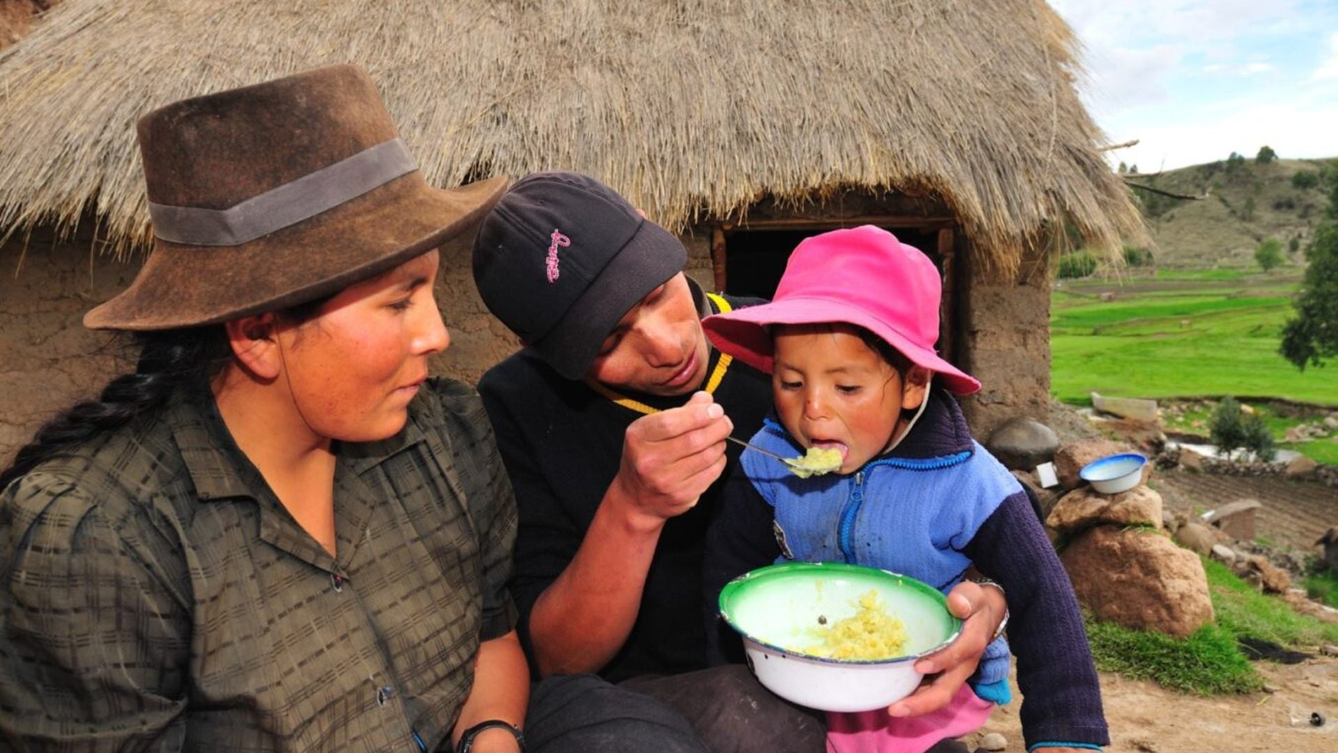 Padres del altiplano dando de comer a su hijo