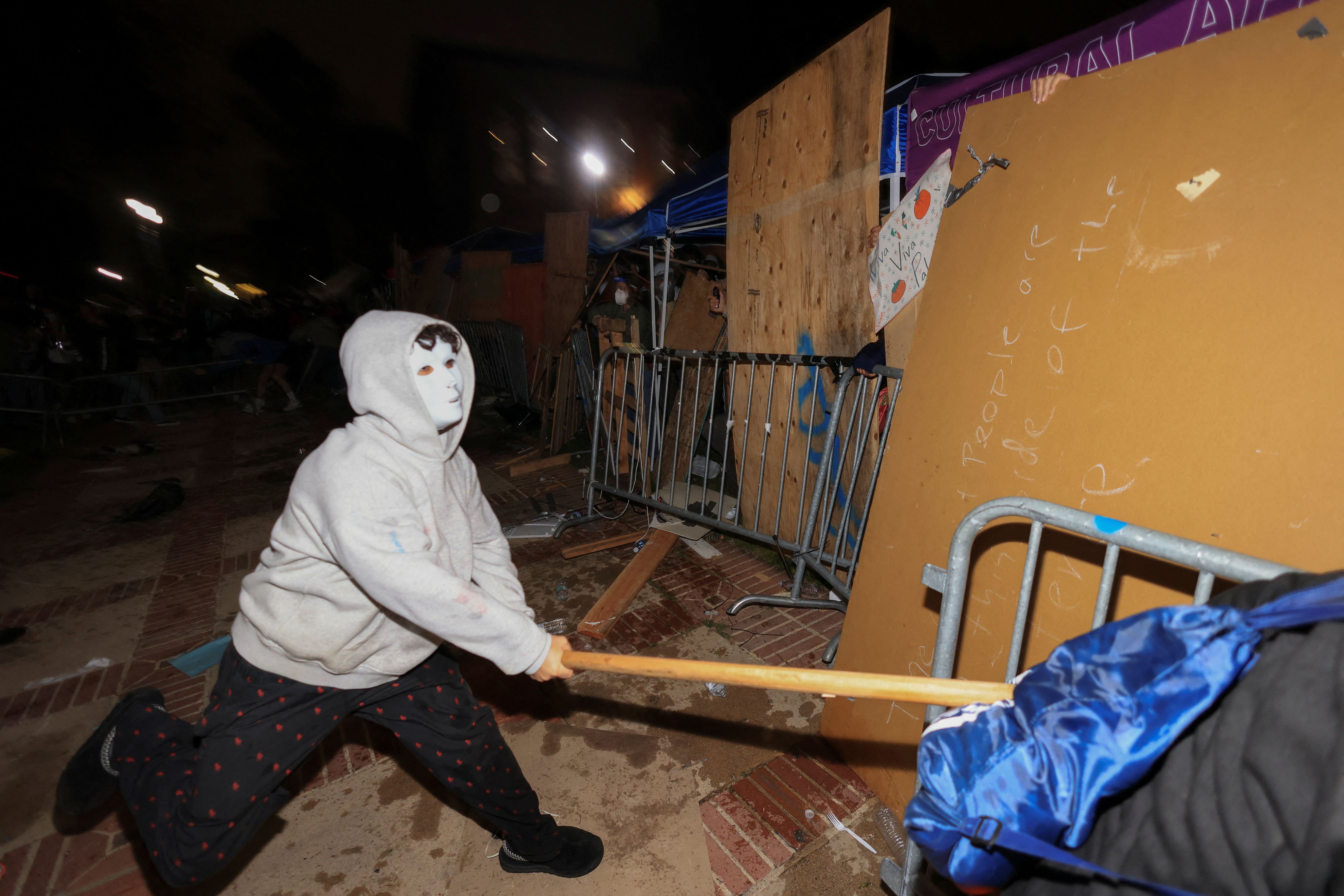 Un contramanifestante golpea una barricada en una acampada propalestina en la Universidad de California. (REUTERS/David Swanson)