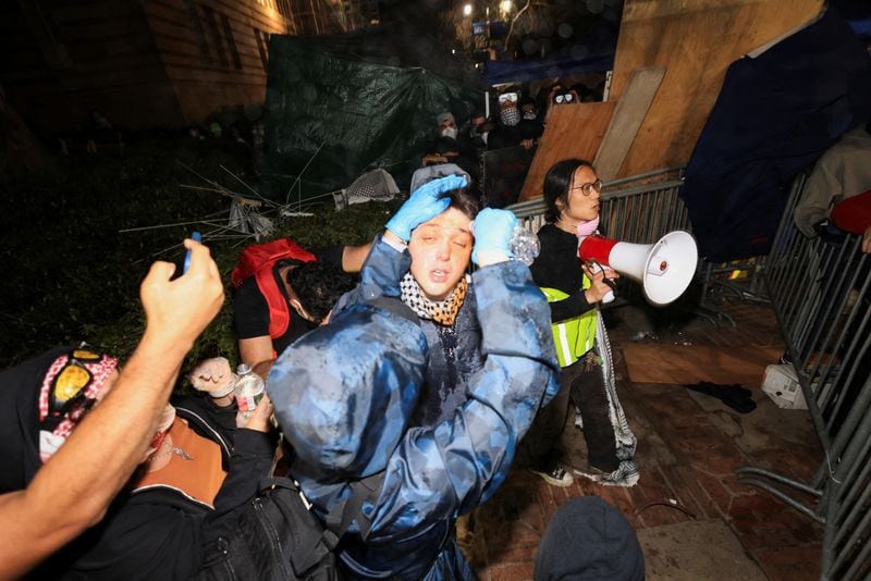 Manifestantes en apoyo a los palestinos de Gaza se ayudan unos a otros a enjuagarse los ojos, en una acampada en el campus de la Universidad de California en Los Ángeles (UCLA) (REUTERS/David Swanson)