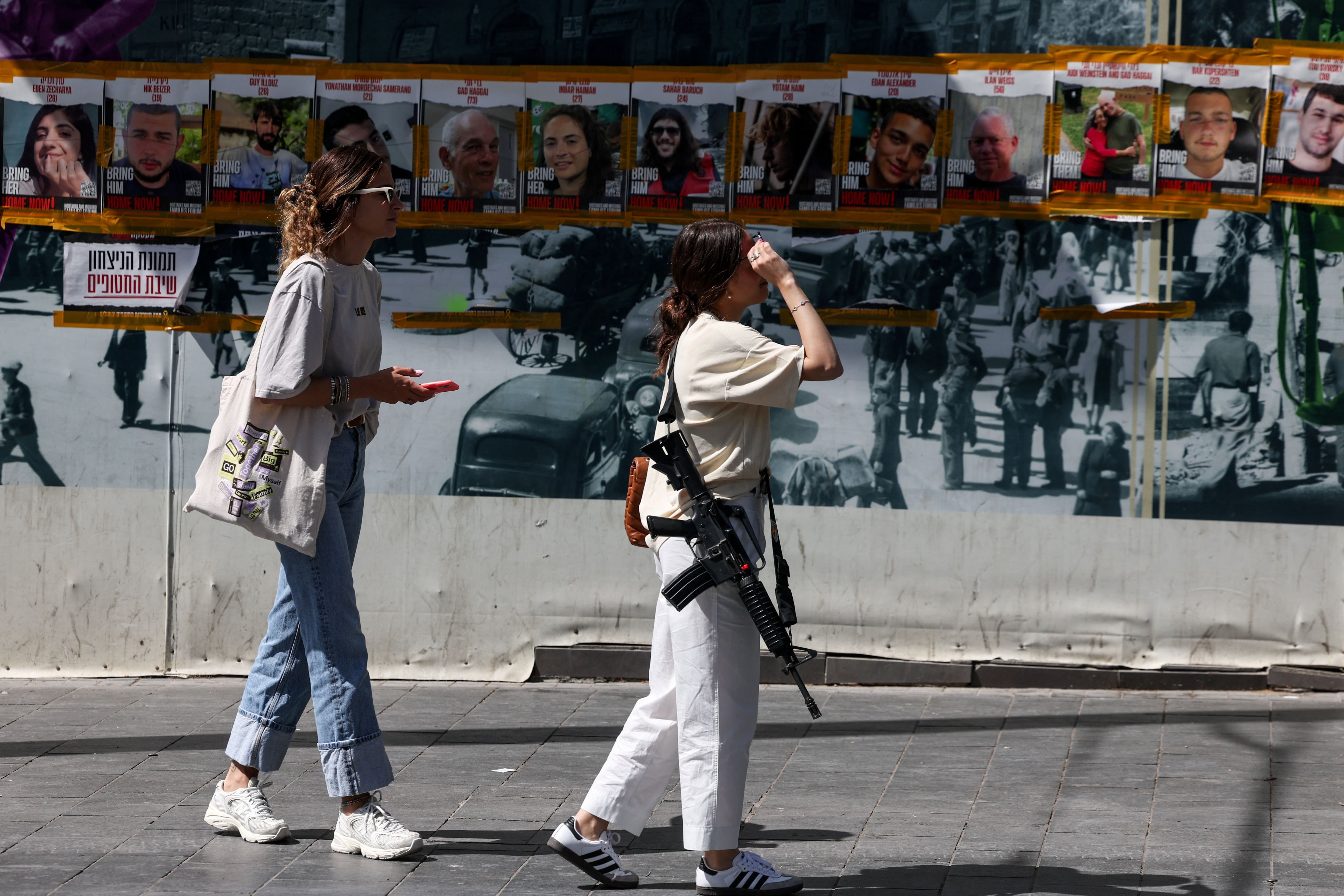 La gente camina cerca de carteles que piden la liberación de los rehenes que fueron secuestrados durante el mortal ataque del 7 de octubre por parte del grupo islamista palestino Hamás, en medio del conflicto en curso en Gaza entre Israel y Hamás, en Jerusalén, el 3 de mayo de 2024. REUTERS/Ronen Zvulun