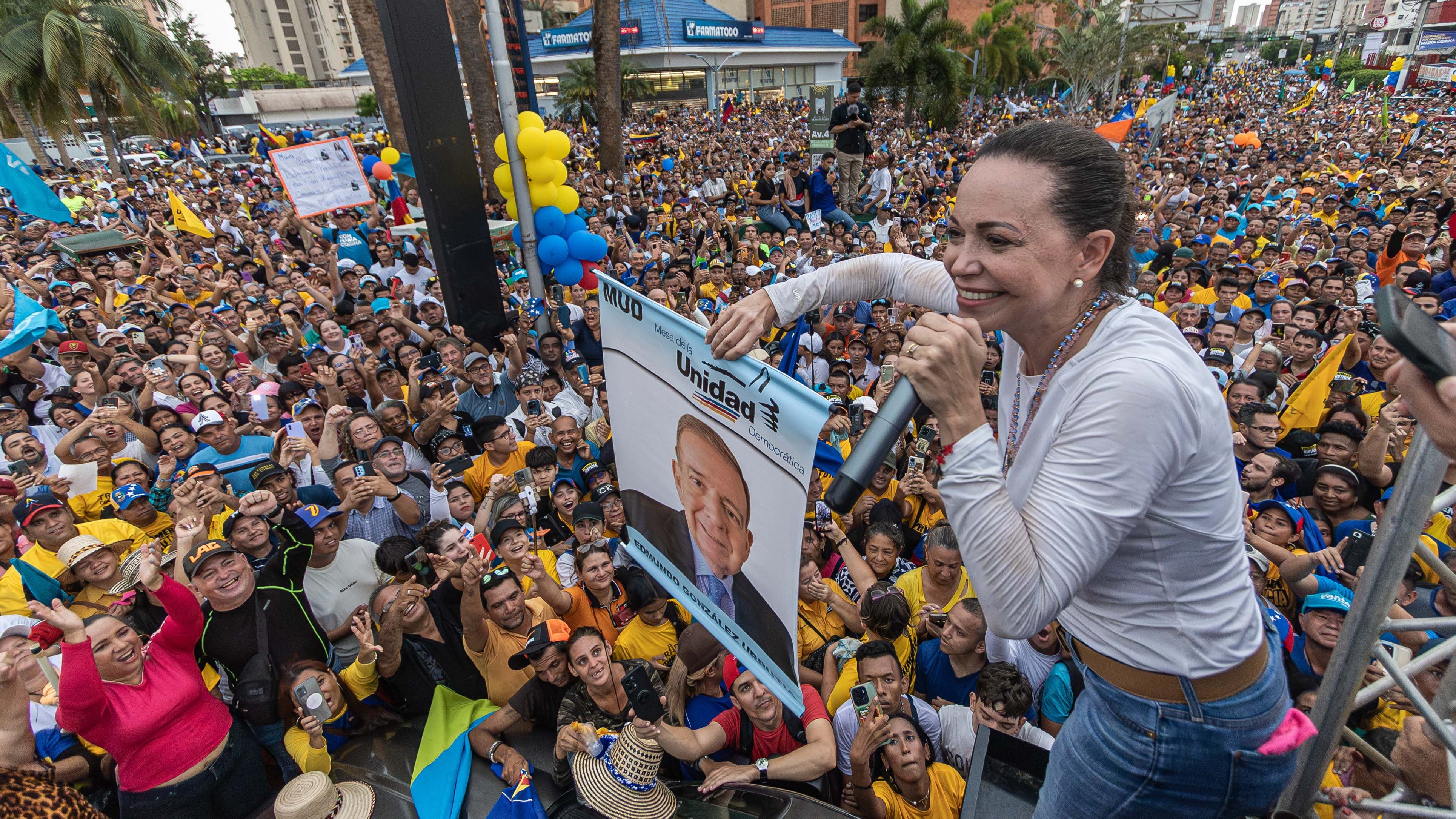 María Corina Machado habla sosteniendo una imagen de González Urrutia en un acto político en una avenida en Maracaibo (EFE/Henry Chirinos)