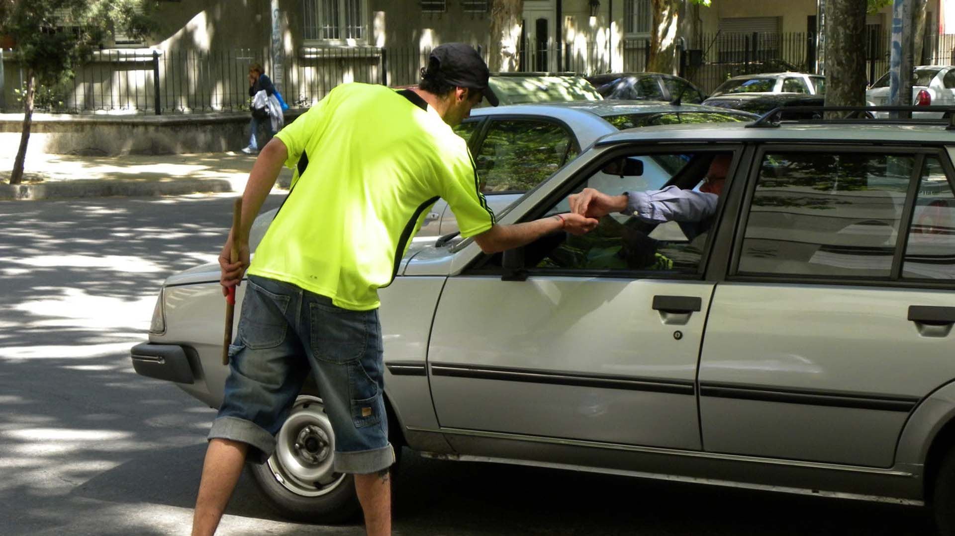 Un "trapito" recibe dinero de un automovilista