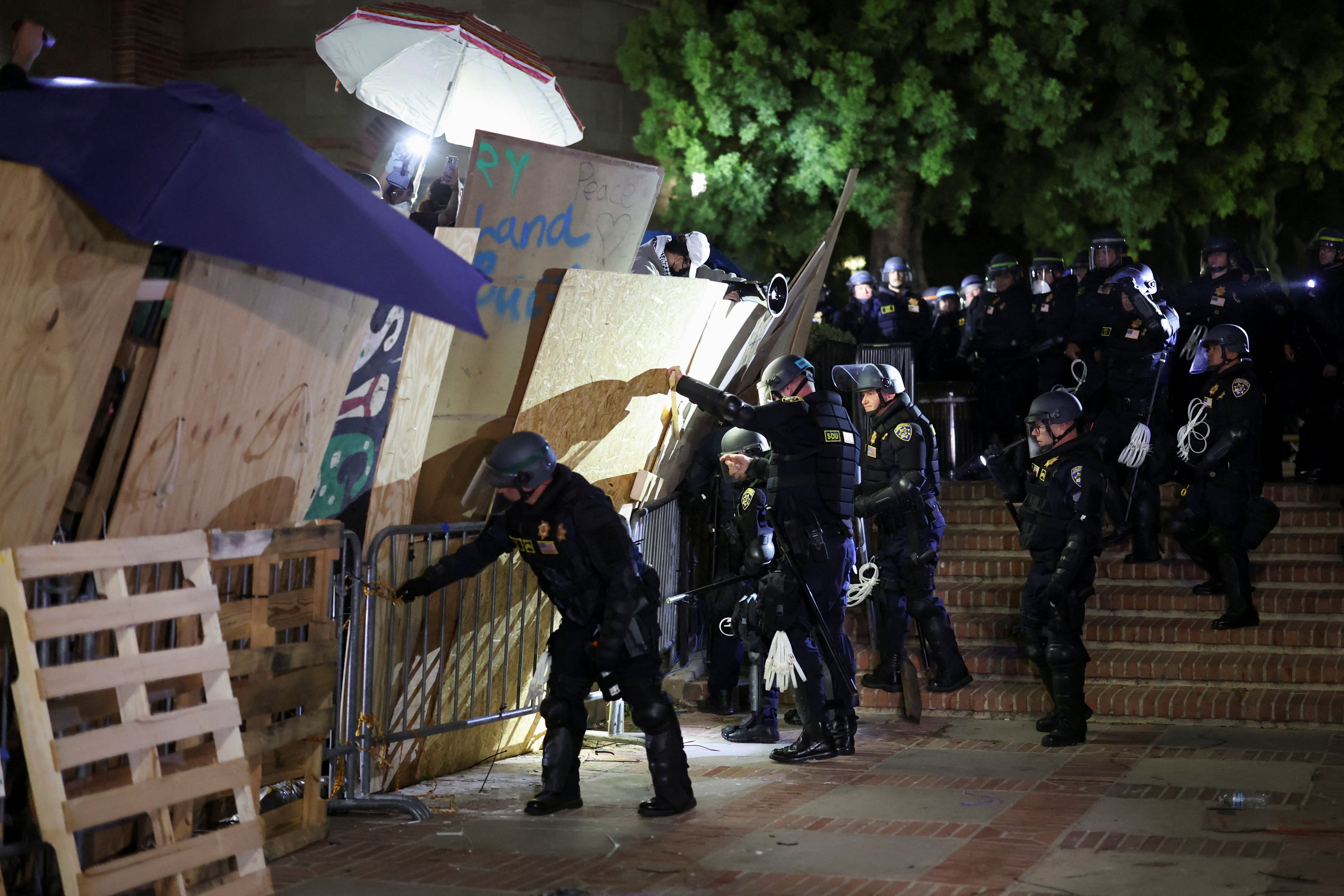 La policía antidisturbios derriba la barricada mientras los manifestantes que apoyan a los palestinos en Gaza se reúnen en un campamento en la Universidad de California en Los Ángeles (UCLA), en medio del conflicto entre Israel y el grupo islamista palestino Hamas, en Los Ángeles, California, Estados Unidos, el 2 de mayo. 2024. REUTERS/Mike Blake