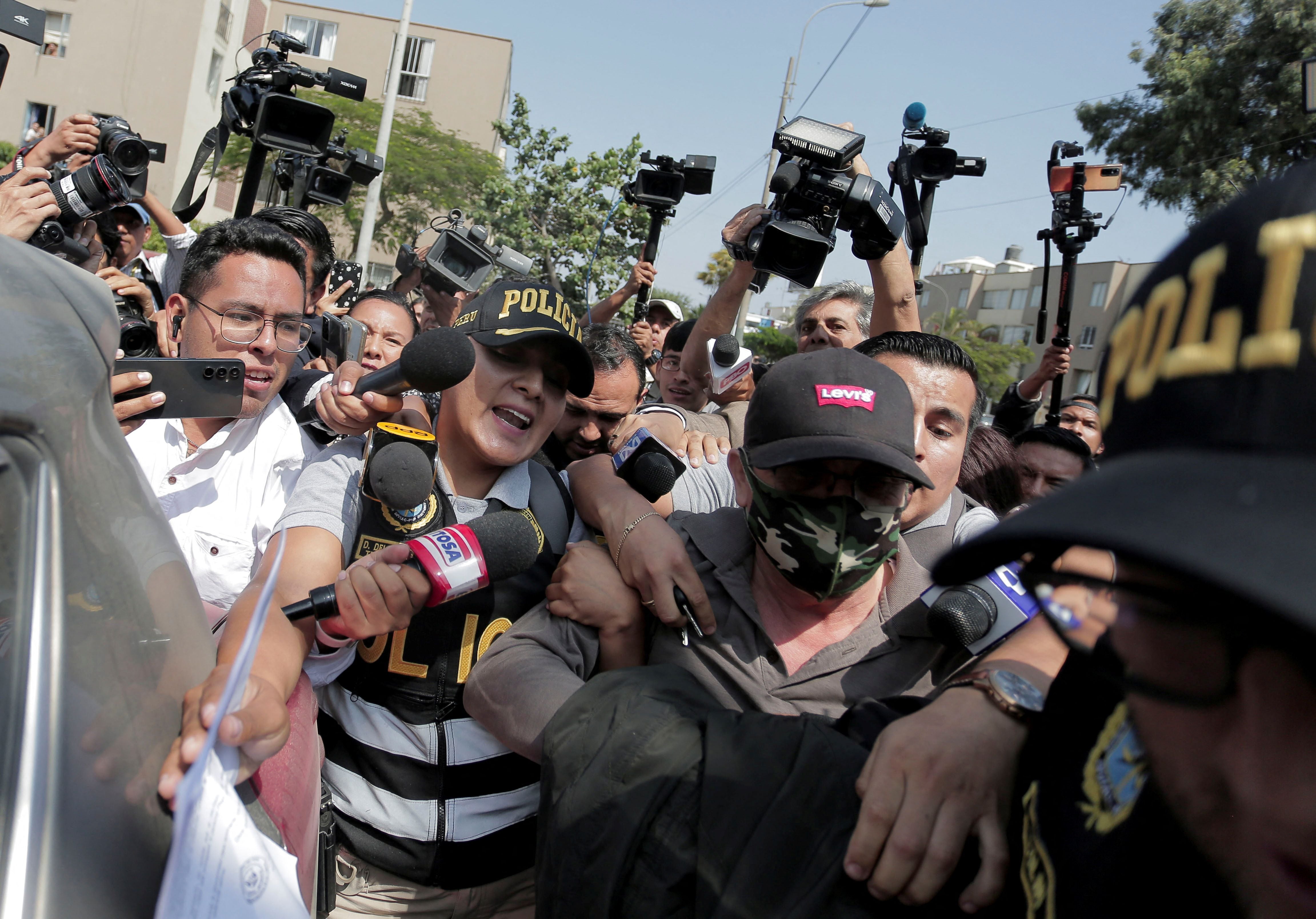 Policías escoltan a Nicanor Boluarte, hermano de la presidenta, mientras sale de su casa, después de que los fiscales lo detuvieran. Foto: REUTERS/Gerardo Marin