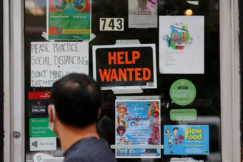 Un peatón pasa junto a un cartel de "Se busca ayuda" en la puerta de una ferretería en Cambridge, Massachusetts, Estados Unidos. REUTERS/Brian Snyder/Archivo