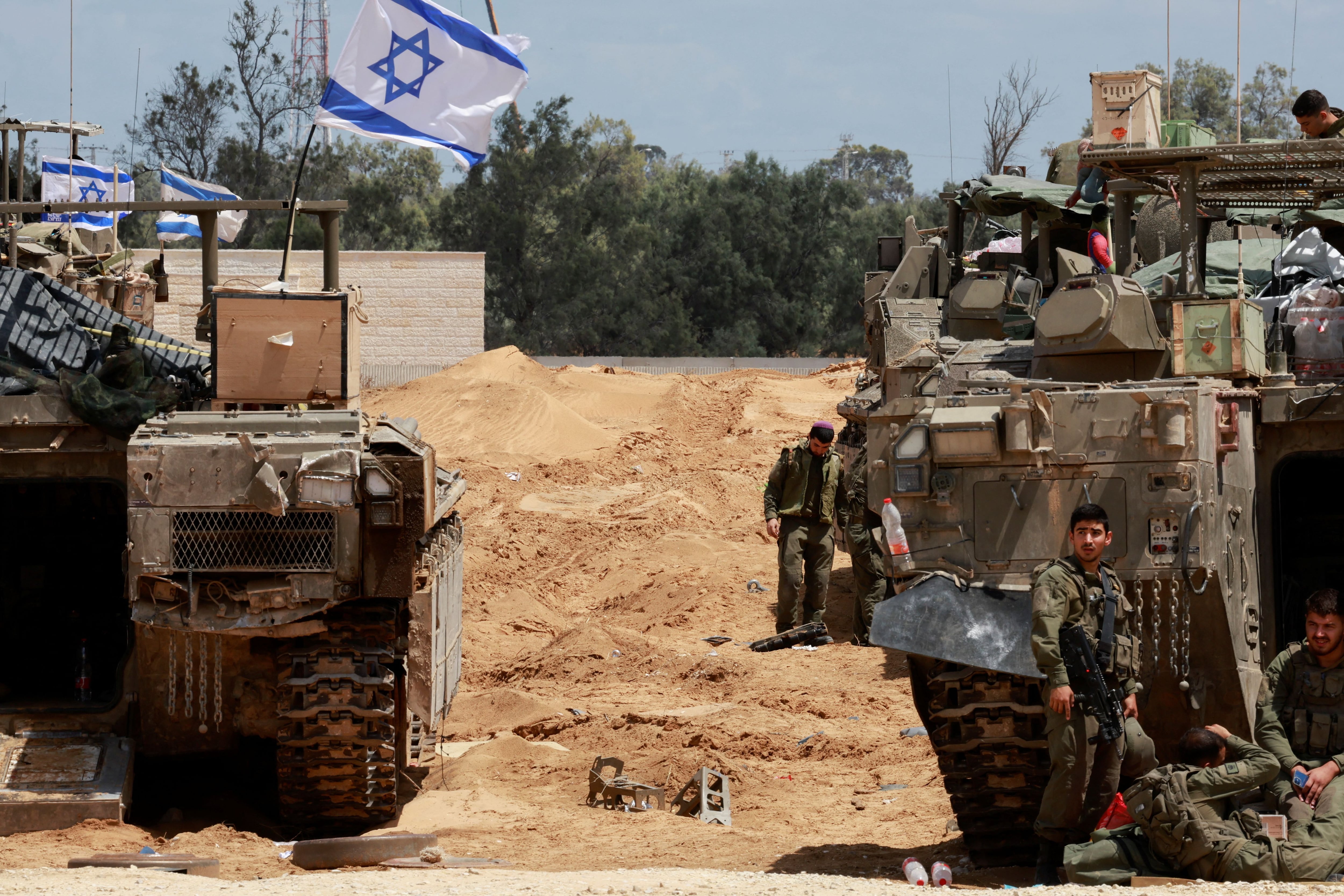 Soldados israelíes se encuentran junto a vehículos militares cerca de la frontera entre Israel y Gaza, en Israel, el 6 de mayo de 2024. REUTERS/Ammar Awad