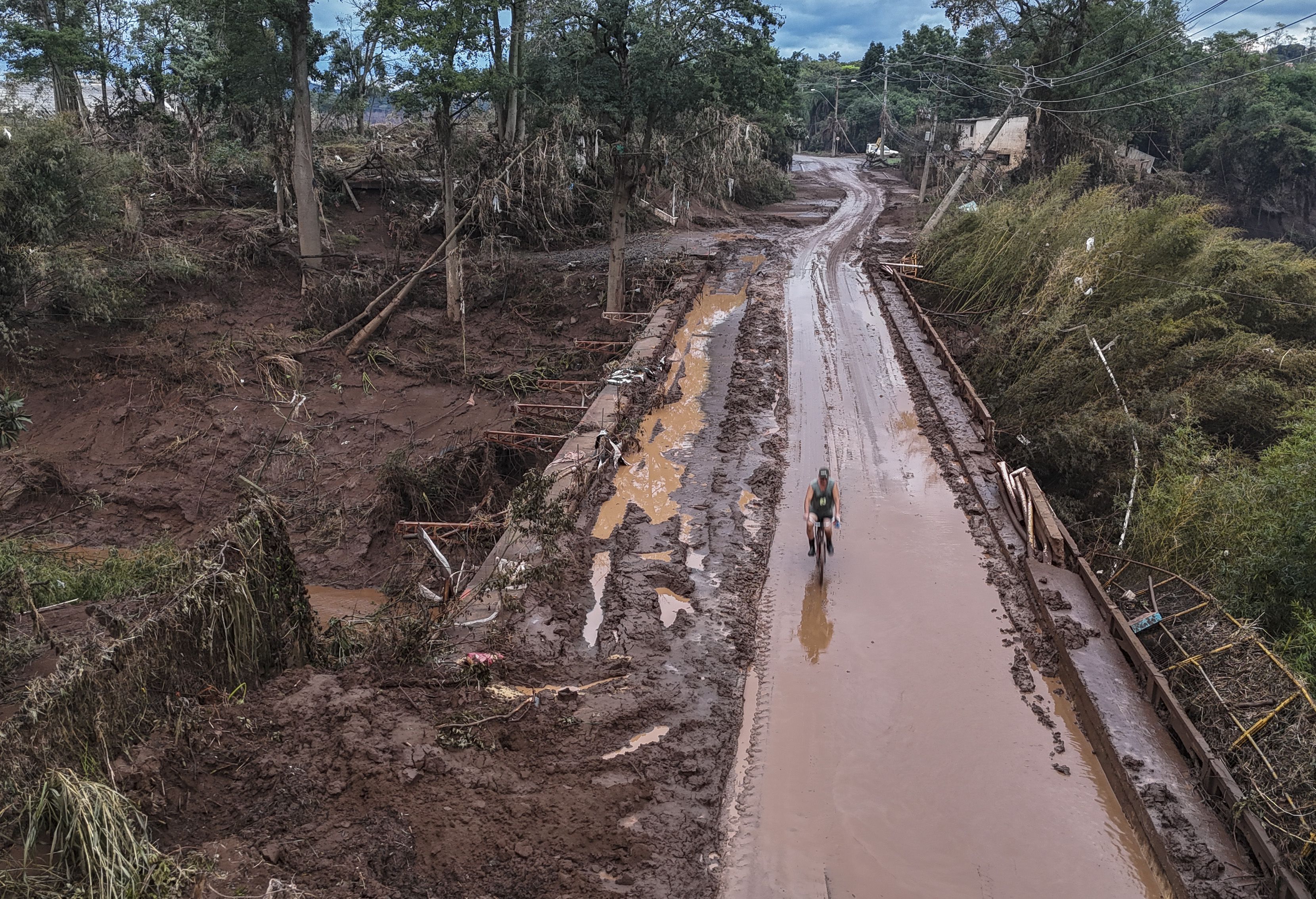 Fotografía tomada con un dron que muestra un ciclista pasando por el puente tras inundación causada por el desbordamiento del río Taquari, en la ciudad de Lajeado en el estado de Rio Grande do Sul en el sur de Brasil. EFE/Sebastião Moreira
