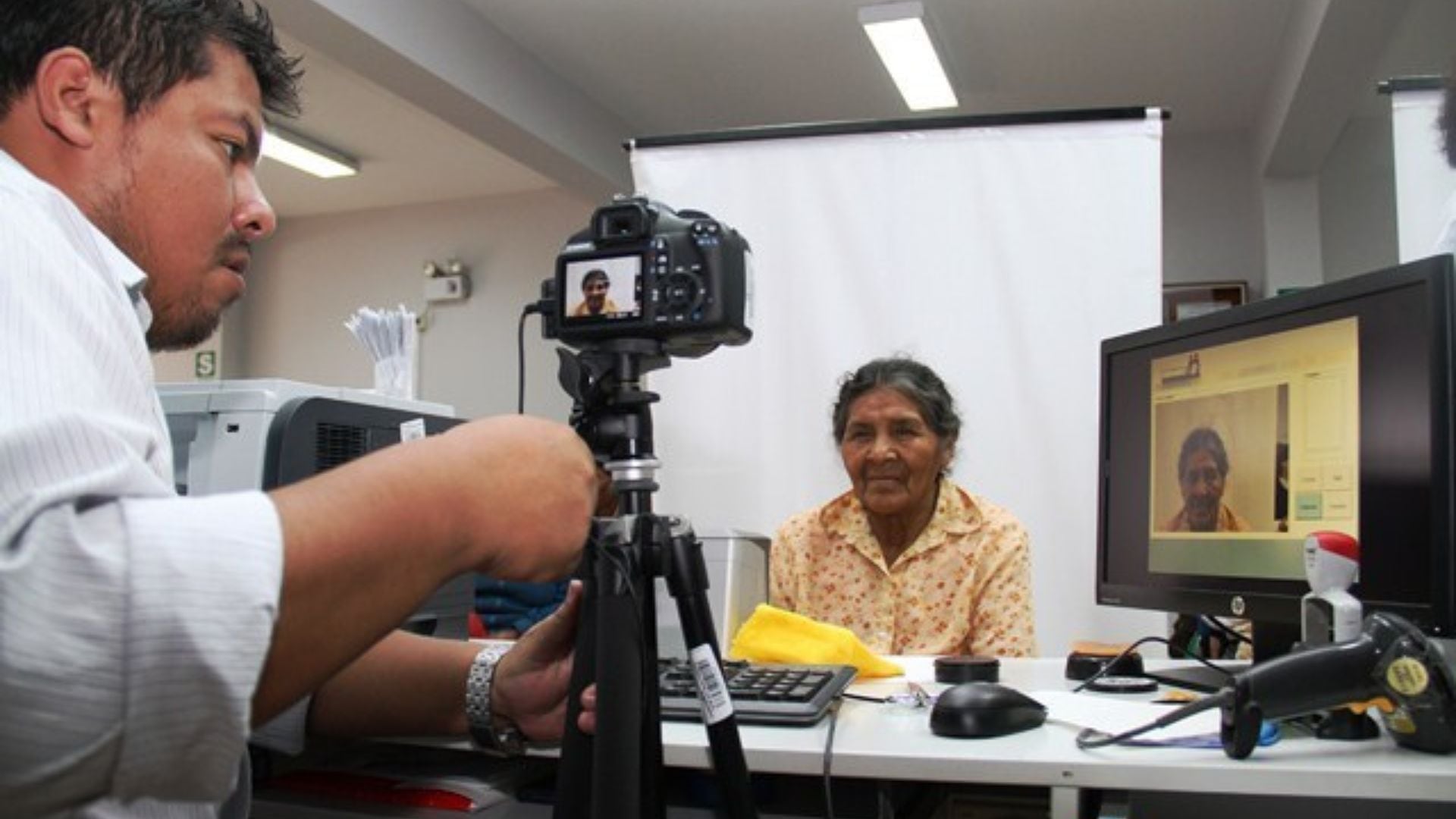 Un funcionario del Reniec toma la fotografía a una adulta mayor en una de las oficinas de la institución para tramitar su DNI electrónico.