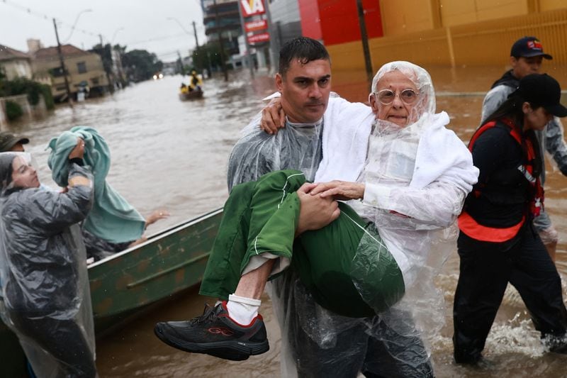 Un voluntario lleva a un hombre, que ha sido evacuado de una zona inundada en Porto Alegre, estado de Rio Grande do Sul (REUTERS/Diego Vara)