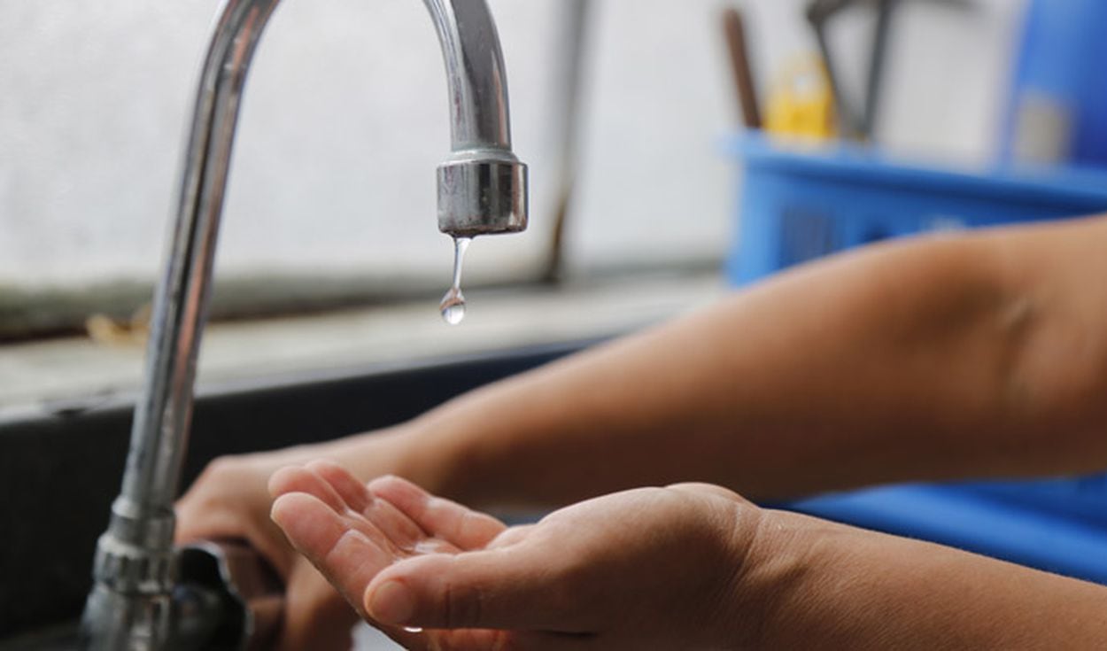 Un ciudadano abre el caño de su cocina, pero solo caen gota de agua potable, tras concretarse un corte del suministro programado.