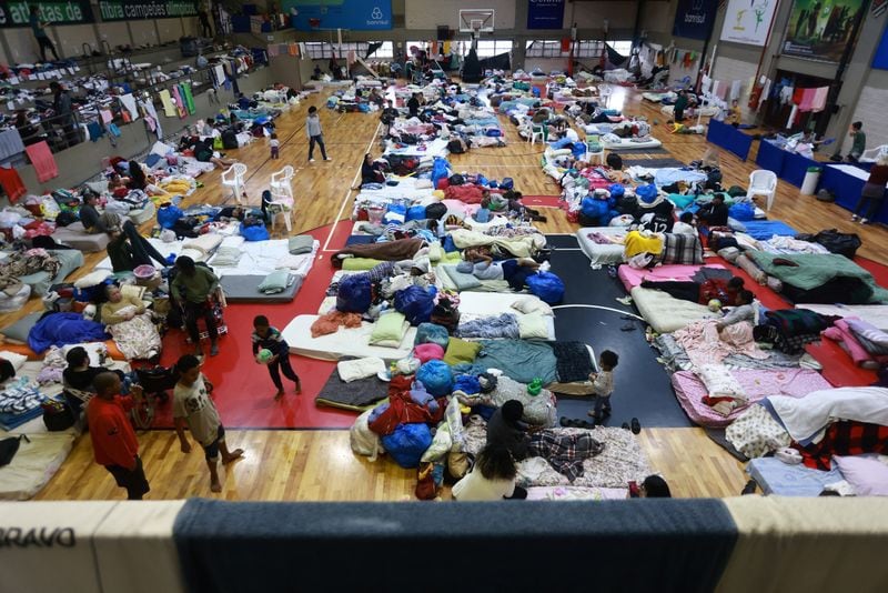 Personas evacuadas de zonas inundadas descansan en un gimnasio utilizado como refugio en Porto Alegre (REUTERS/Diego Vara)