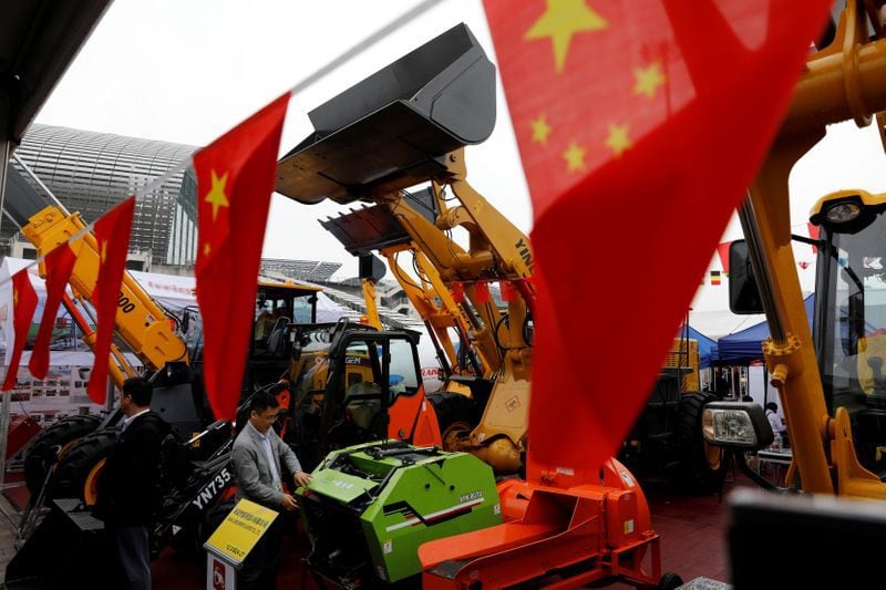 FOTO DE ARCHIVO: Banderas chinas frente a vehículos de construcción durante la Feria de Importación y Exportación de China, también conocida como Feria de Cantón, celebrada en la ciudad de Guangzhou, China, el 16 de abril de 2018. REUTERS/Tyrone Siu