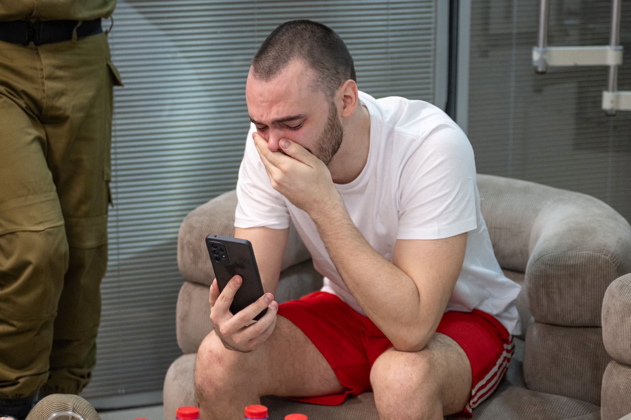 Andrey Kozlov, un rehén rescatado, reacciona mientras usa su teléfono, después de que el ejército dijera que las fuerzas israelíes rescataron vivos a cuatro rehenes de la zona central de la Franja de Gaza, en Ramat Gan, Israel, en esta imagen obtenida por Reuters el 8 de junio de 2024. Ejército israelí/Folleto vía REUTERS