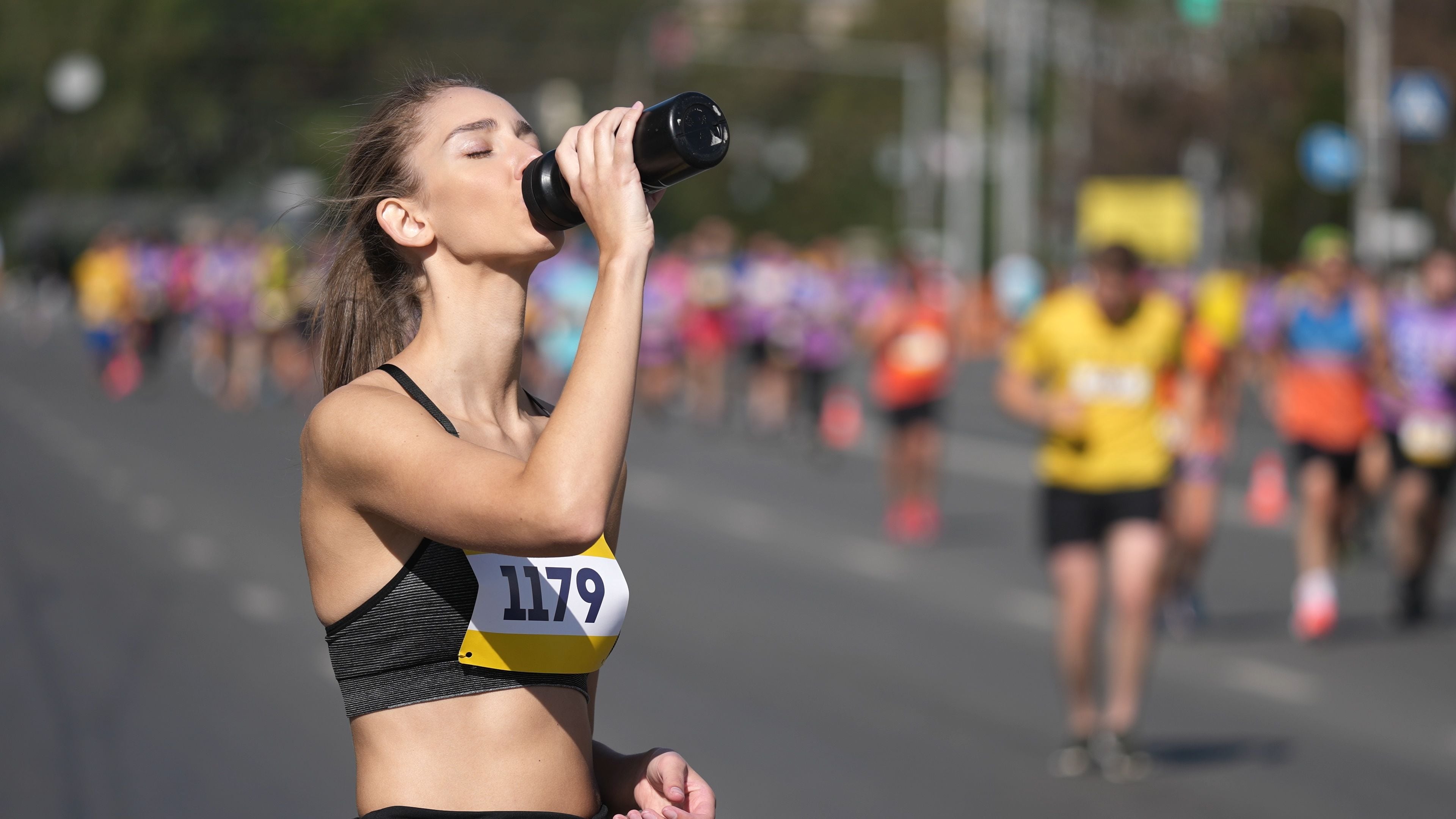 Una atleta se hidrata durante una maratón. (Shutterstock)