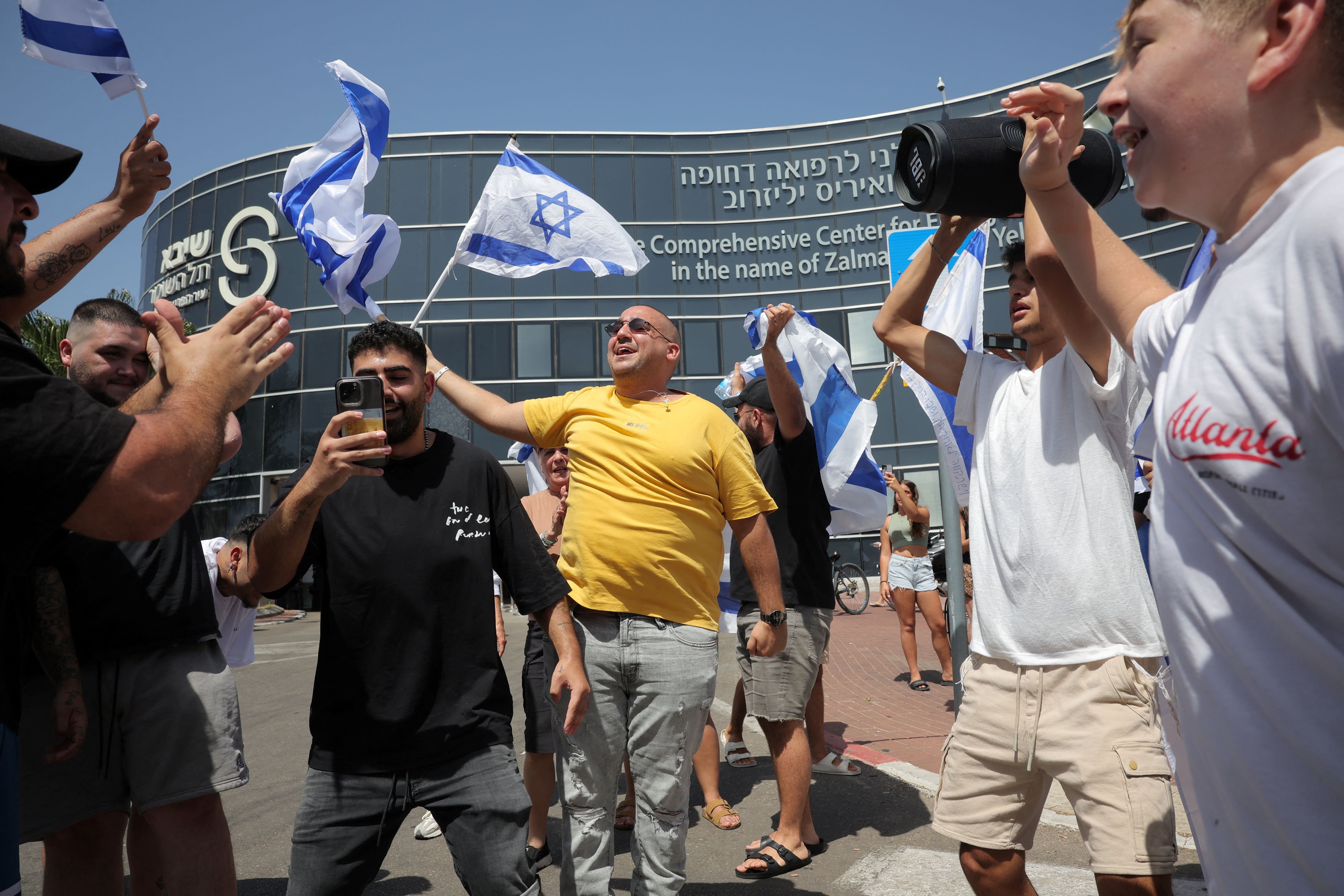 La gente reacciona fuera de un centro médico, después de que los militares dijeran que las fuerzas israelíes rescataron vivos a cuatro rehenes de la Franja de Gaza central el sábado, en Ramat Gan, Israel, el 8 de junio de 2024. REUTERS/Marko Djurica