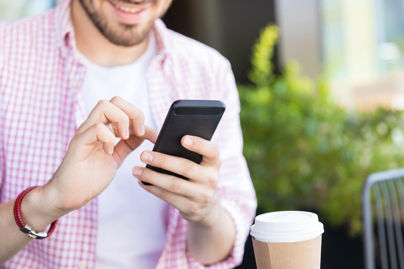 Hombre usando su teléfono celular en un café (Freepik)