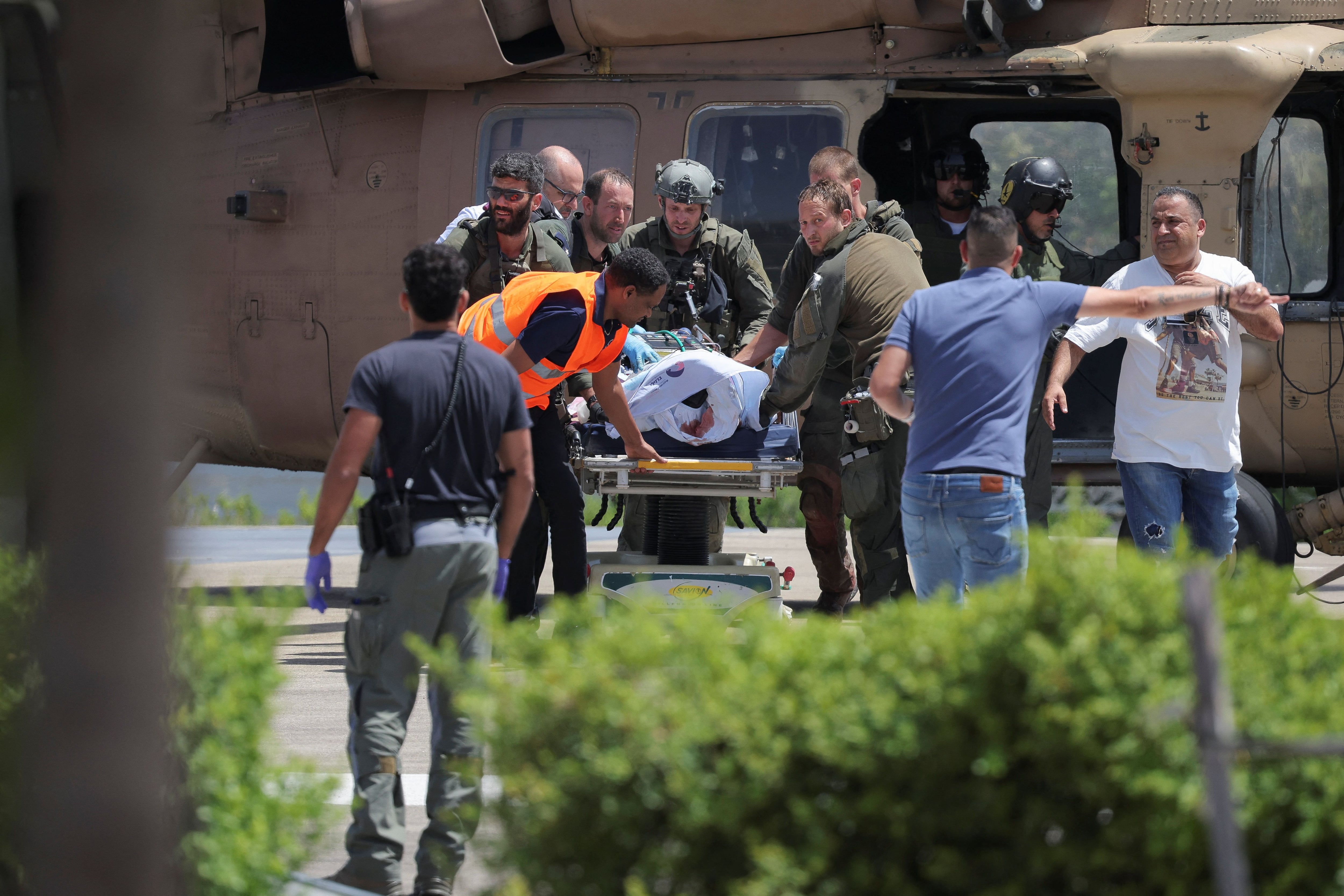 La gente se reúne alrededor de una camilla, después de que los militares dijeran que las fuerzas israelíes rescataron vivos a cuatro rehenes de la Franja de Gaza central el sábado, en Ramat Gan, Israel, el 8 de junio de 2024. REUTERS/Marko Djurica