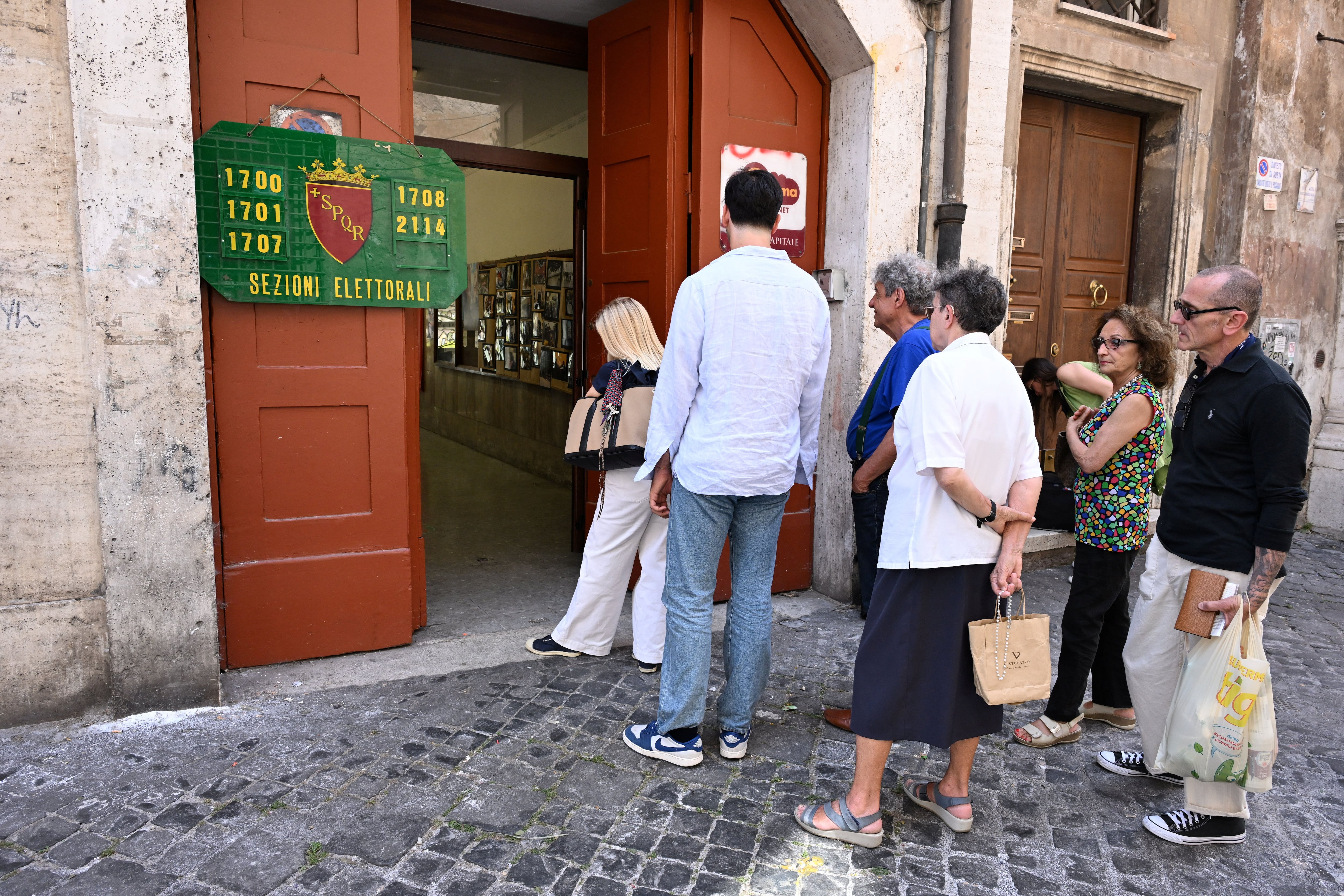 Un grupo de personas espera para votar en un colegio electoral de Roma (REUTERS/Alberto Lingria)