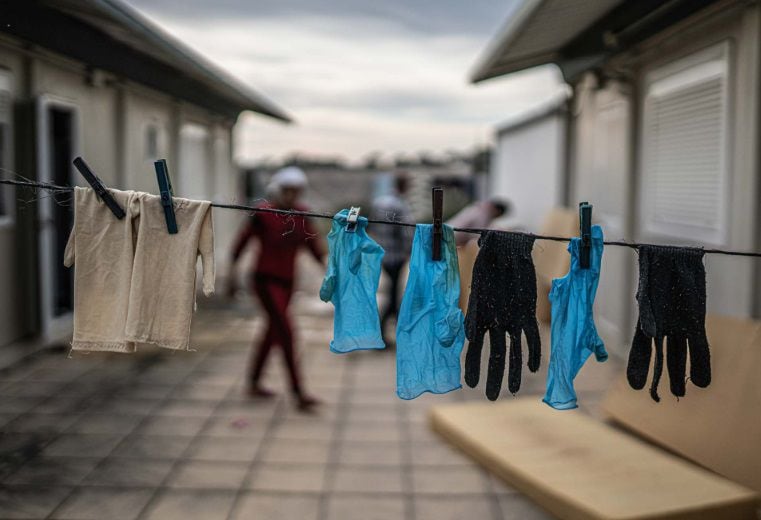 Guantes de trabajo tendidos en la zona de residencia de personas migrantes que trabajan en una explotación agrícola. (Pablo Tosco/Oxfam Intermón)